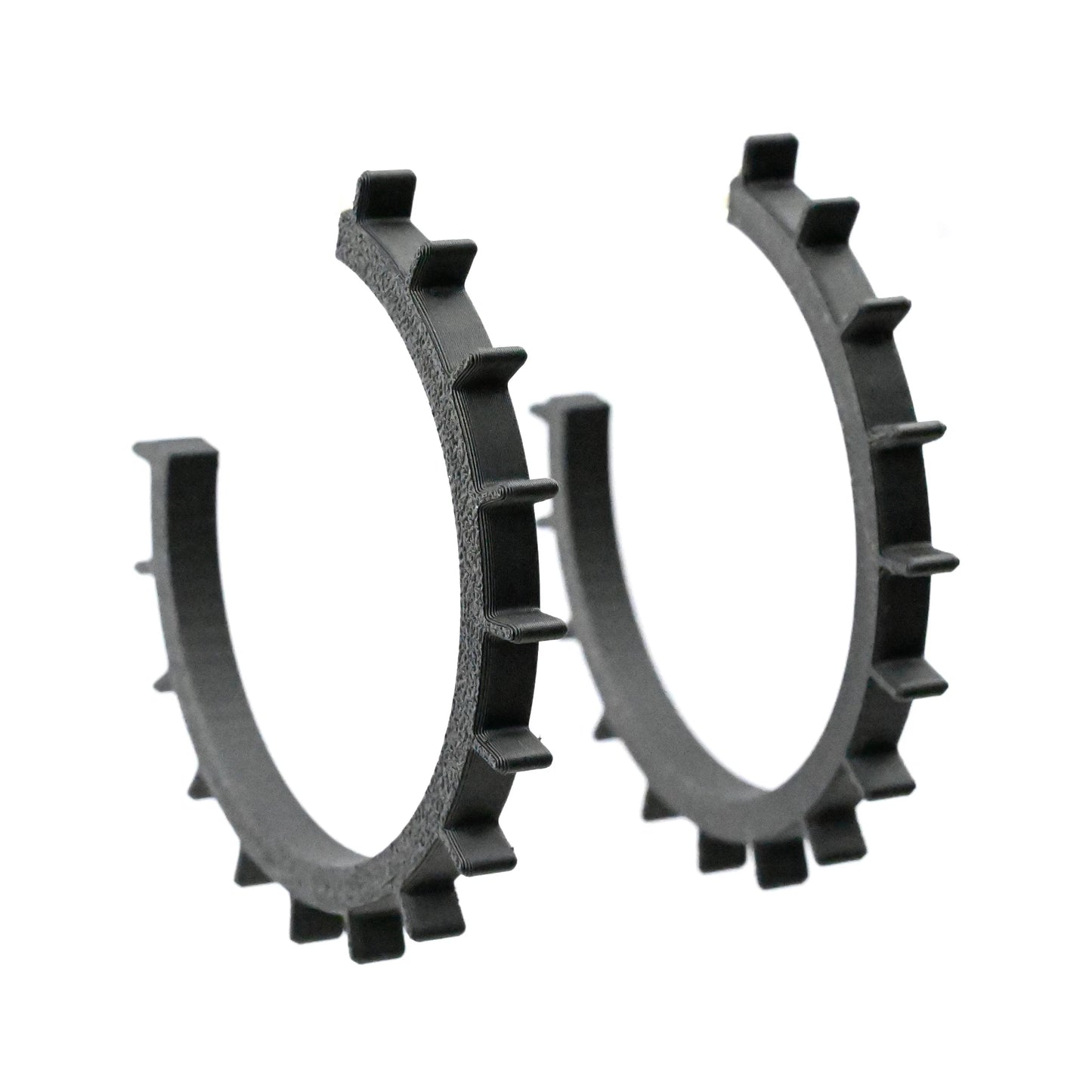 Very big black 3D printed hoop earrings with textured sides on a white background