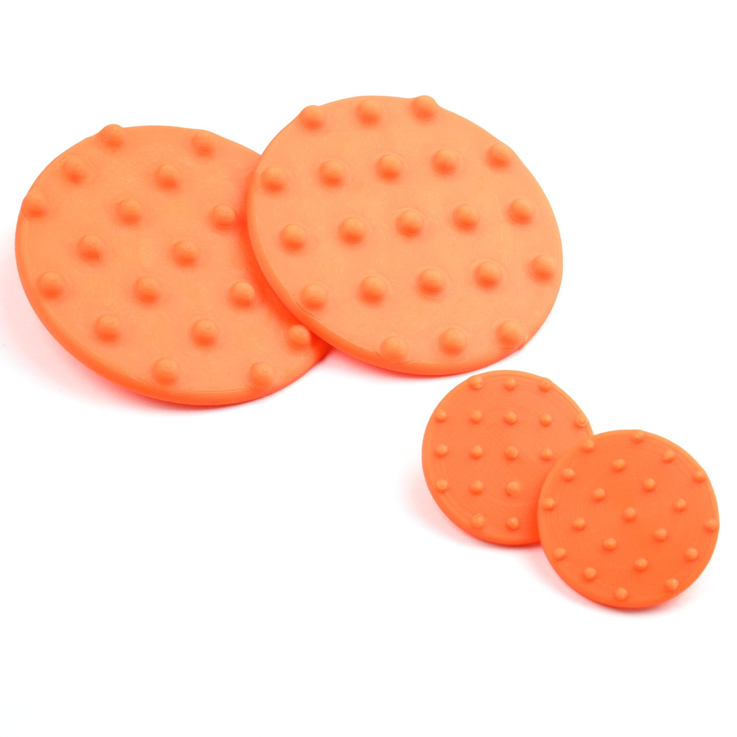A pair of large and a pair of small orange round disk earrings with raised dot pattern on a white background
