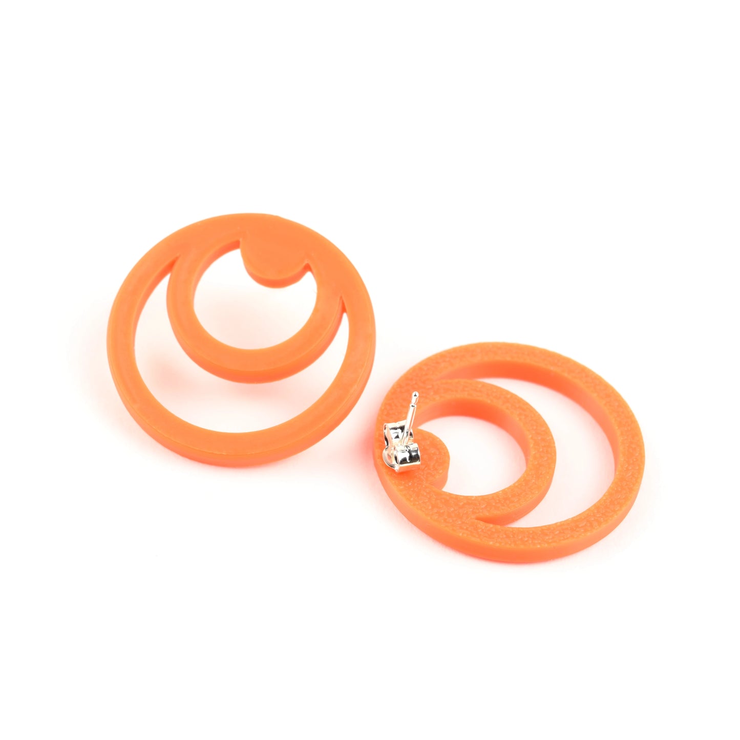 Orange twin circle shaped earrings on a white background