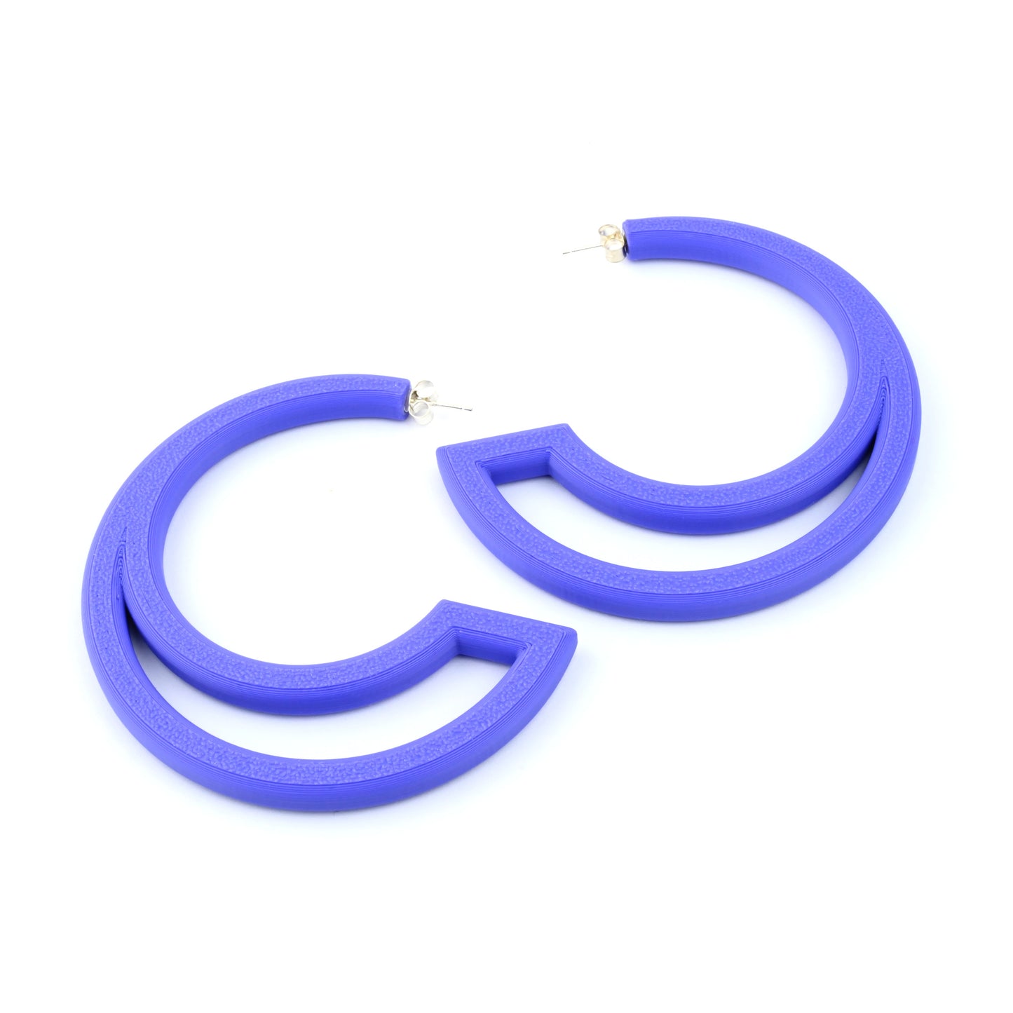 Purple hoop earrings with large curved cut out section on a white background
