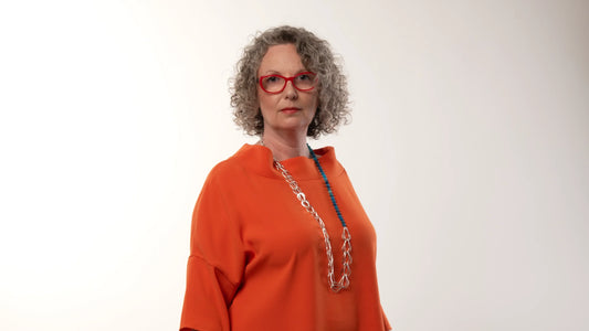 Victoria Hopkins stood in an orange top wearing a silver chain