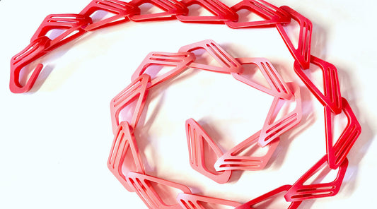 Red and pink chain looped in a spiral on a white background