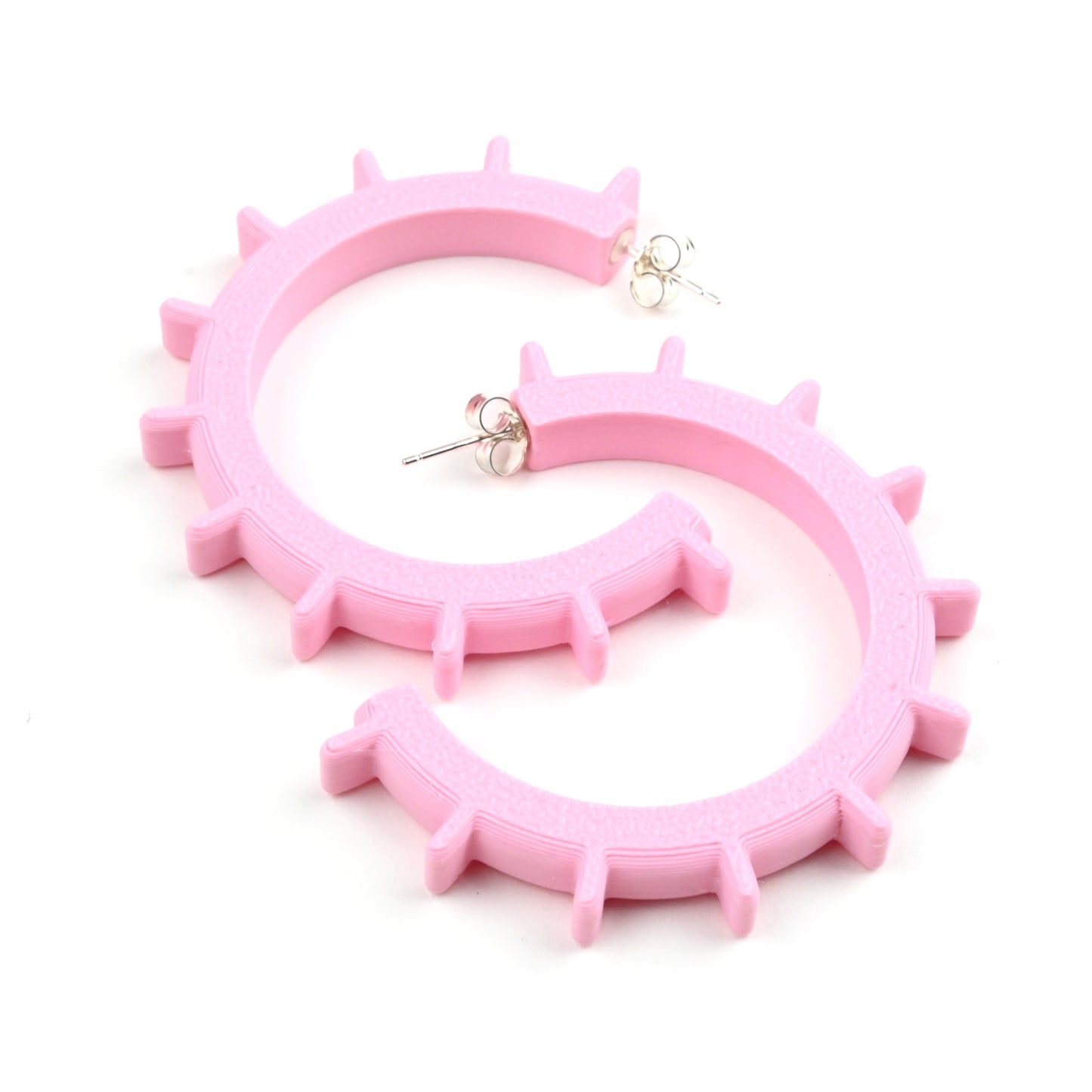 Medium sized pale pink hoop earrings made from plastic with silver ear posts and silver scroll earring backs.  The hoops have pink ridges around the outside of the hoops.