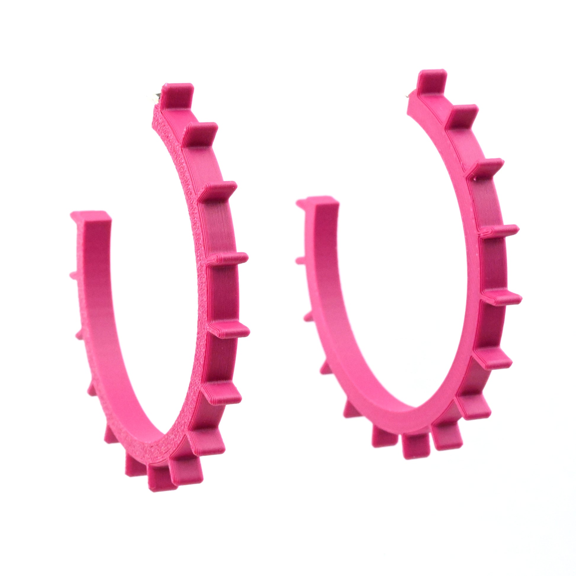 Pair of large plum coloured hoop earrings with ridges around the outside edges on a white background.