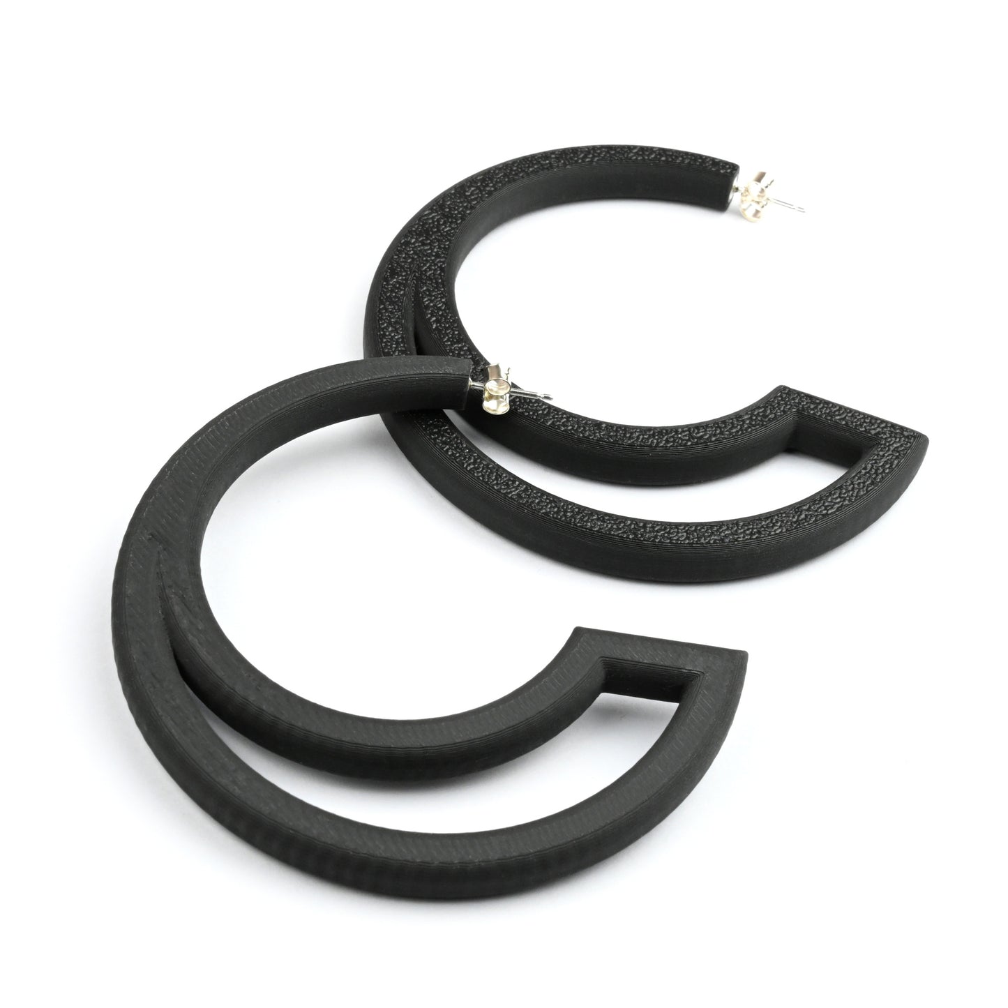 Black hoop earrings with large cut out section on a white background