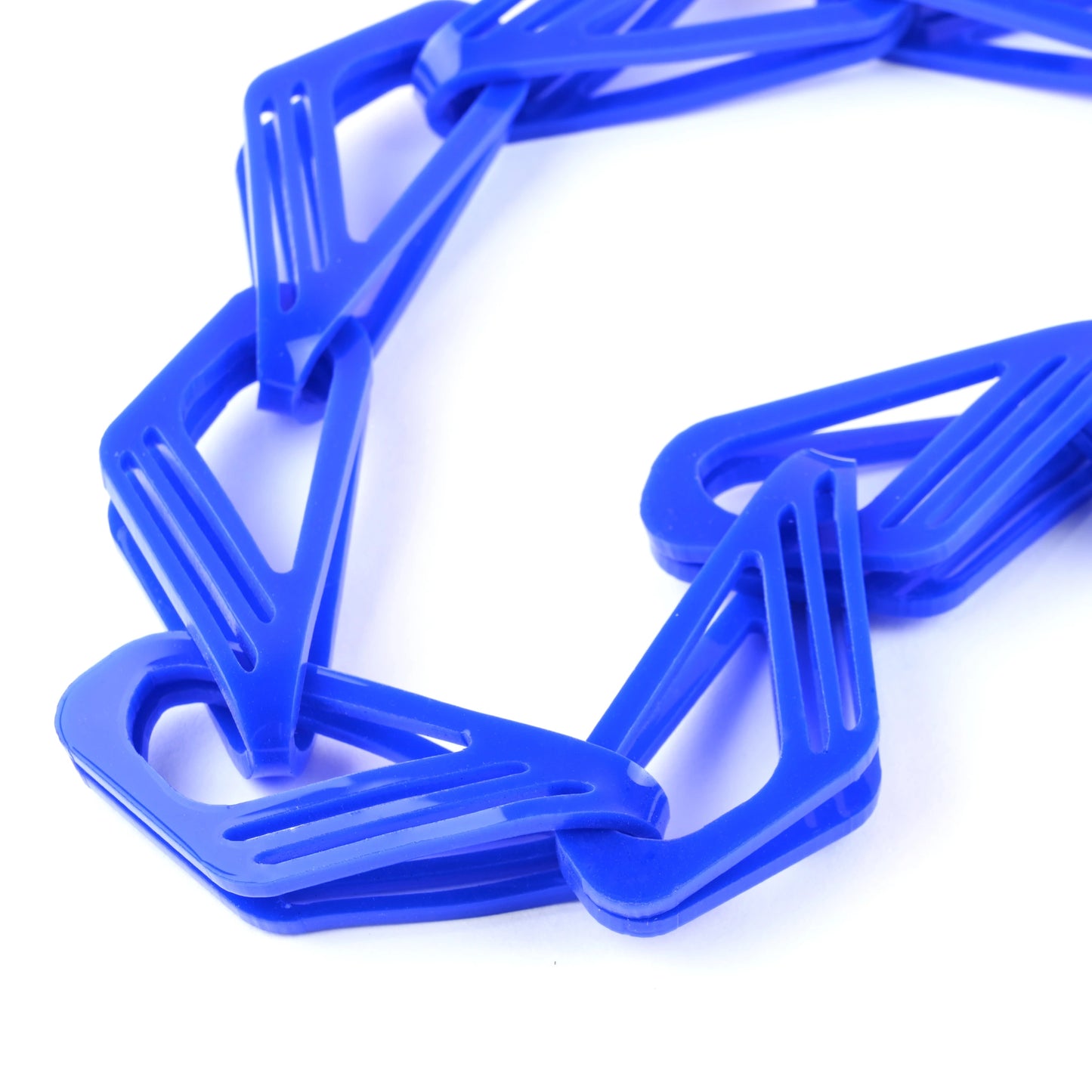 Blue plastic necklace chain links in a bold repeating curved geometric design on a white background