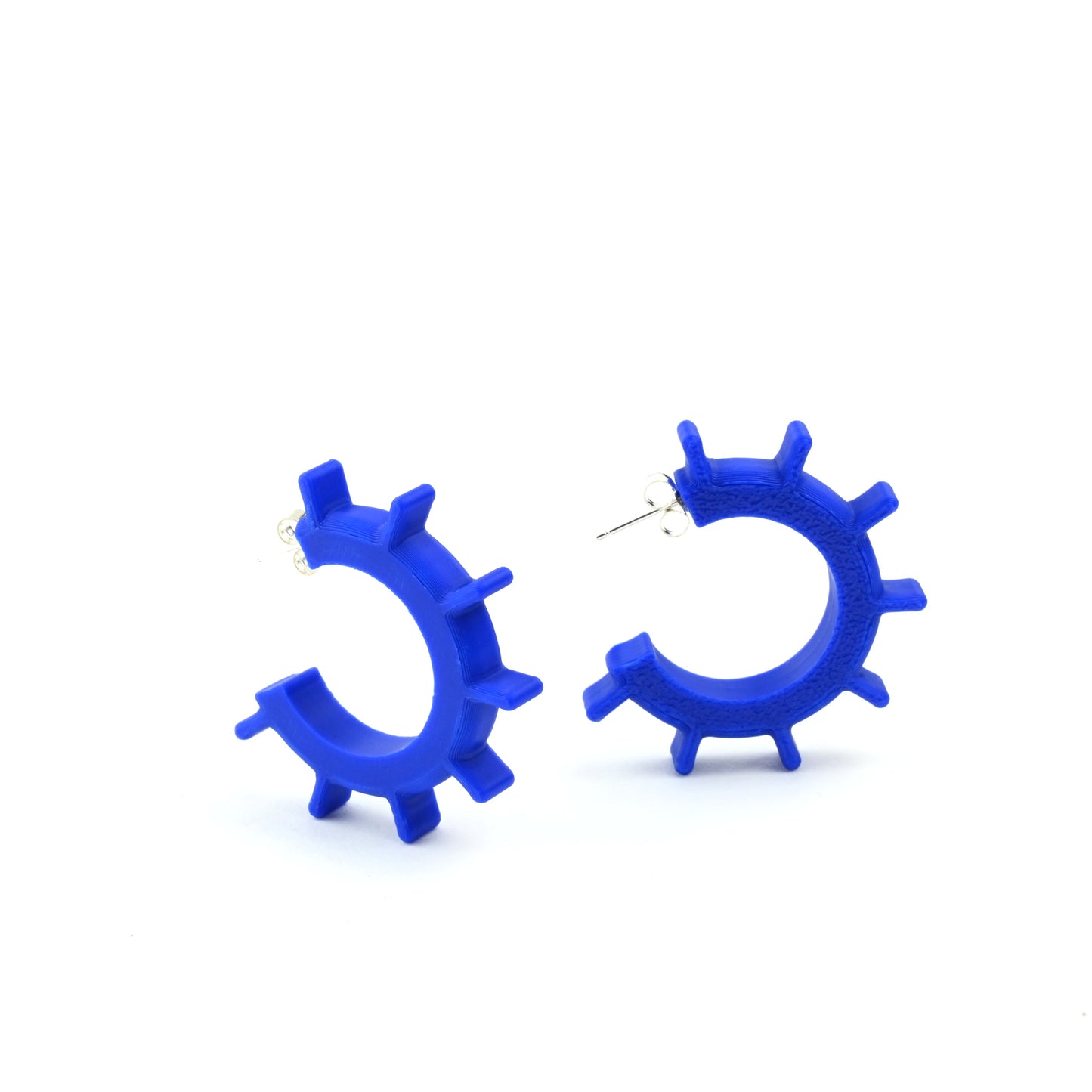 Blue hoop earrings with ridged design and silver ear posts on a white background
