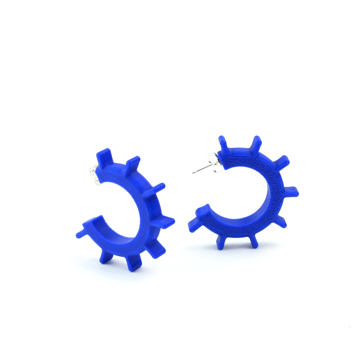 Blue hoop earrings with ridged design and silver ear posts on a white background