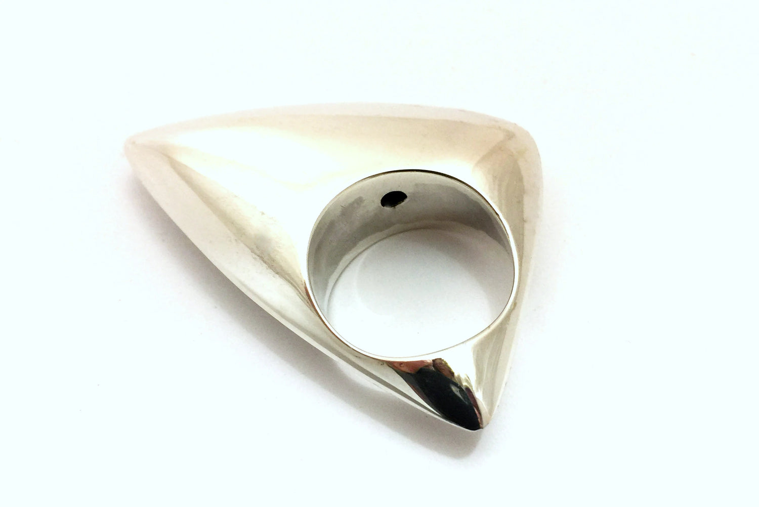 Curved asymmetric triangular domed siler ring against a white backgound