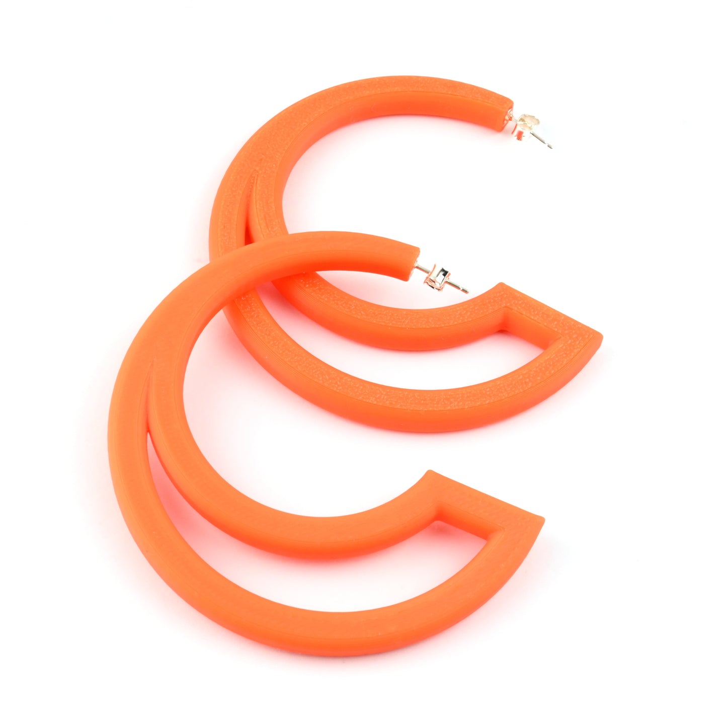 Orange hoop earrings with large cut out section on a white background