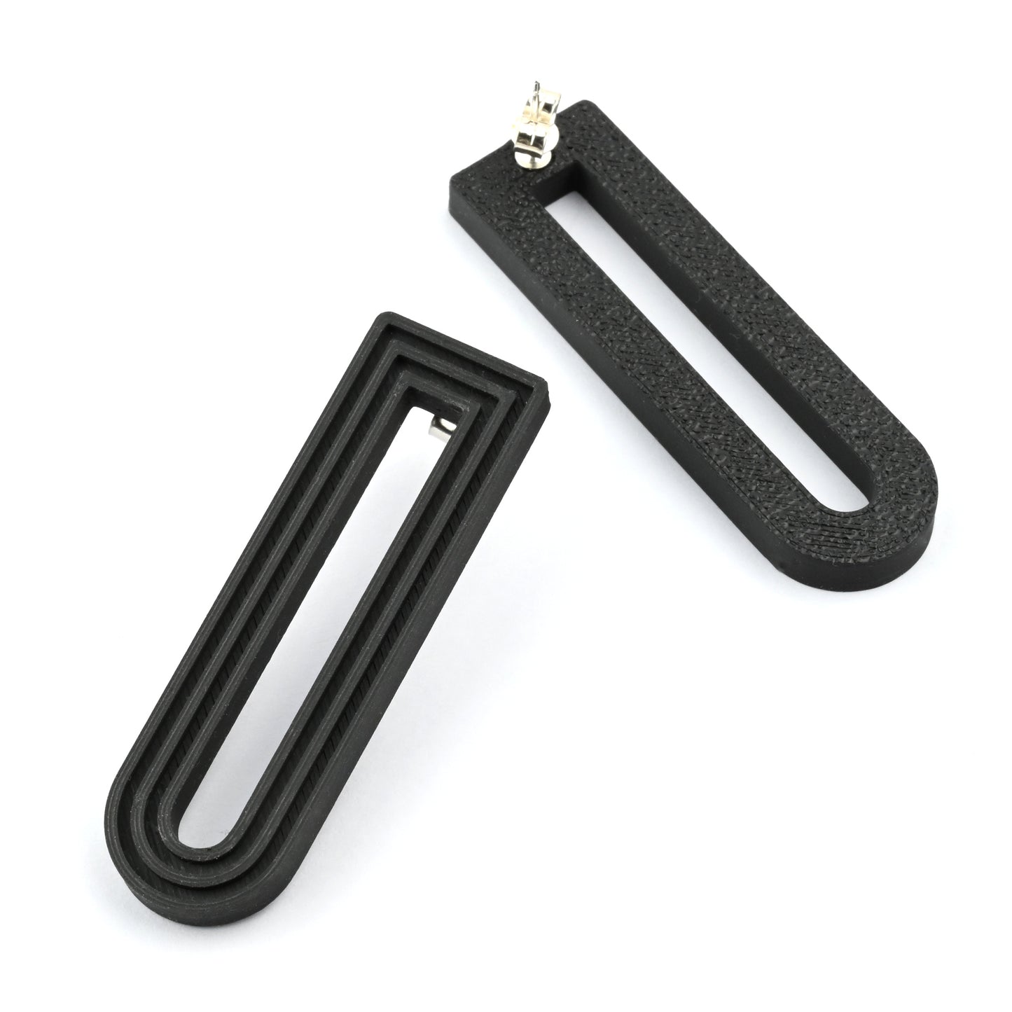Pair of black U-shaped drop earrings with raised linear design on a white background