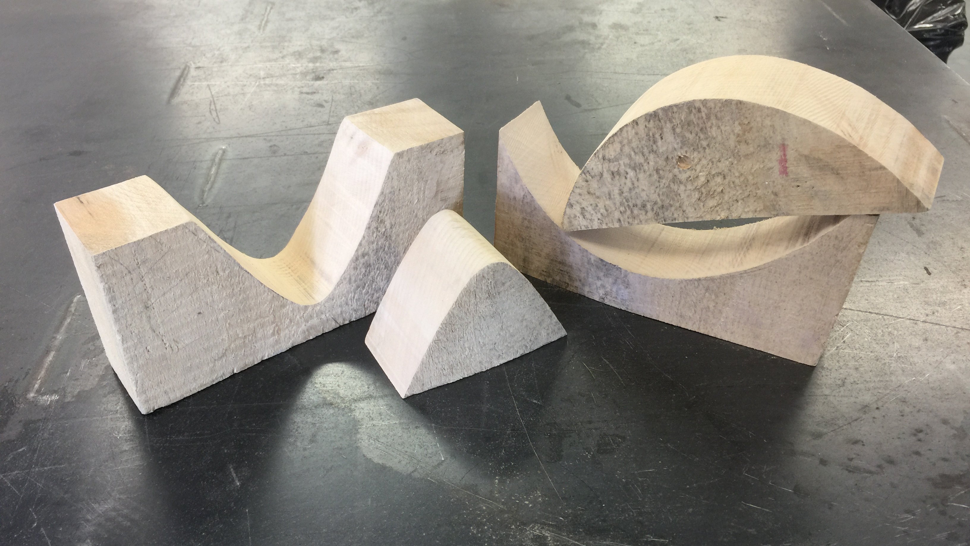 Blocks of wood with cut out curved section in the middle used as a mould.