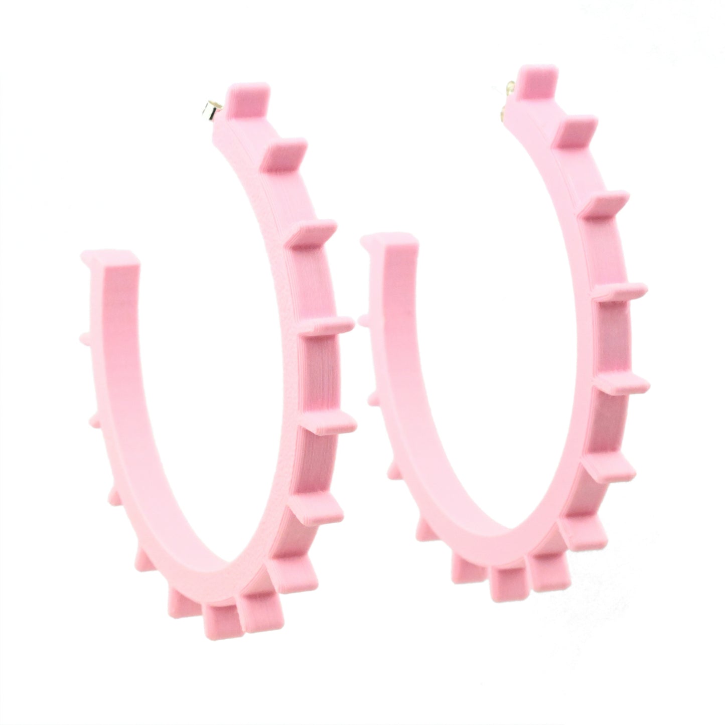 Huge pale pink plastic hoop earrings with ridges along the front edge of the earrings.  