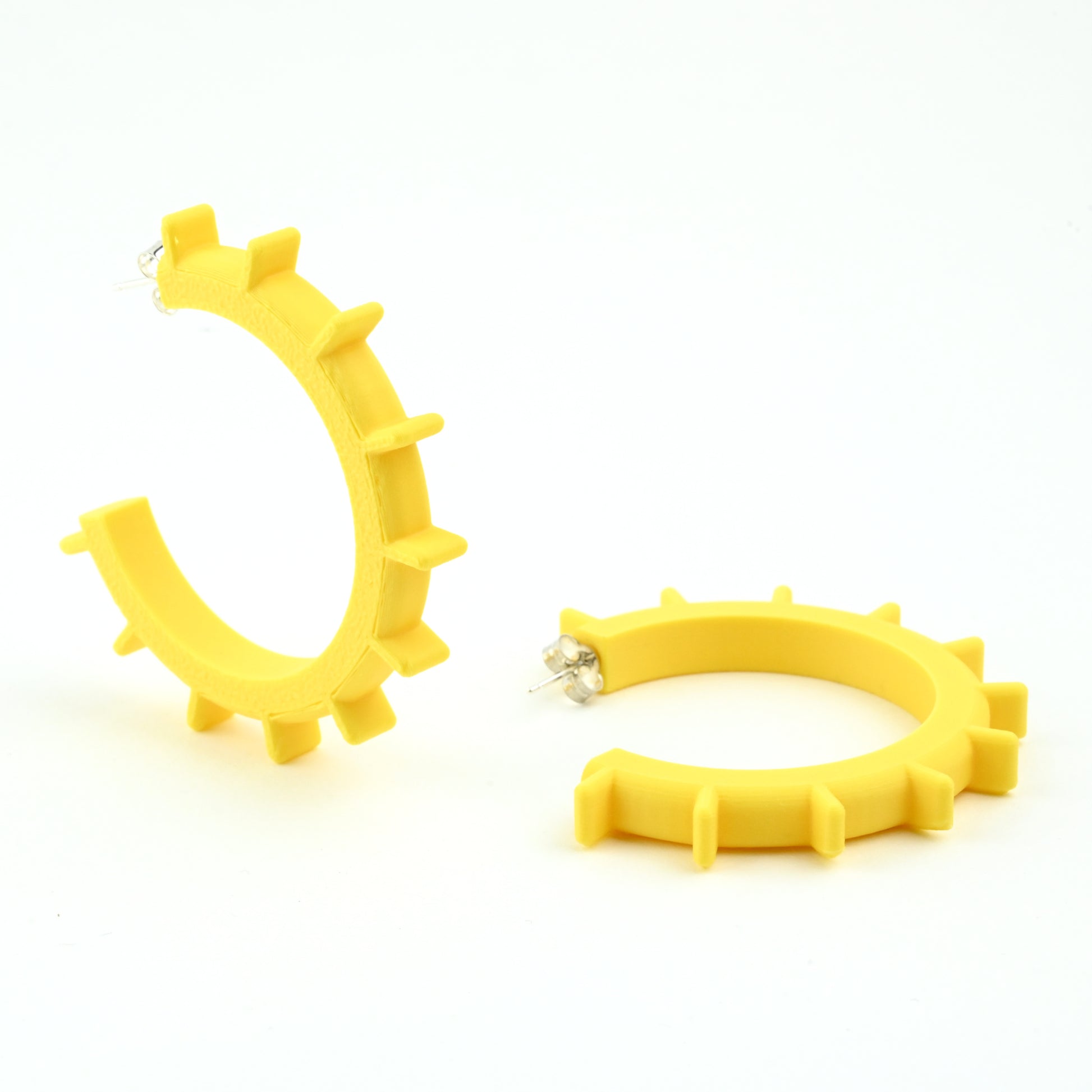 Yellow hoop earings with silver ear posts on a white background