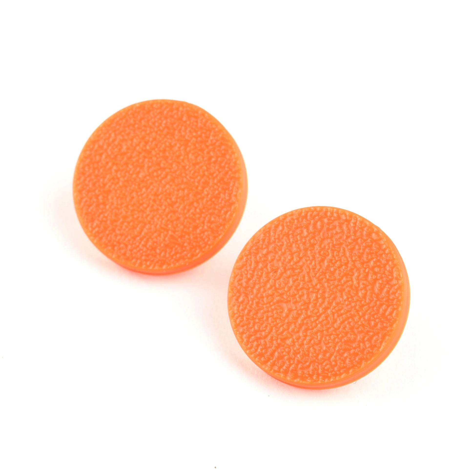 Two orange round stud earrings with a textured surface on a white background