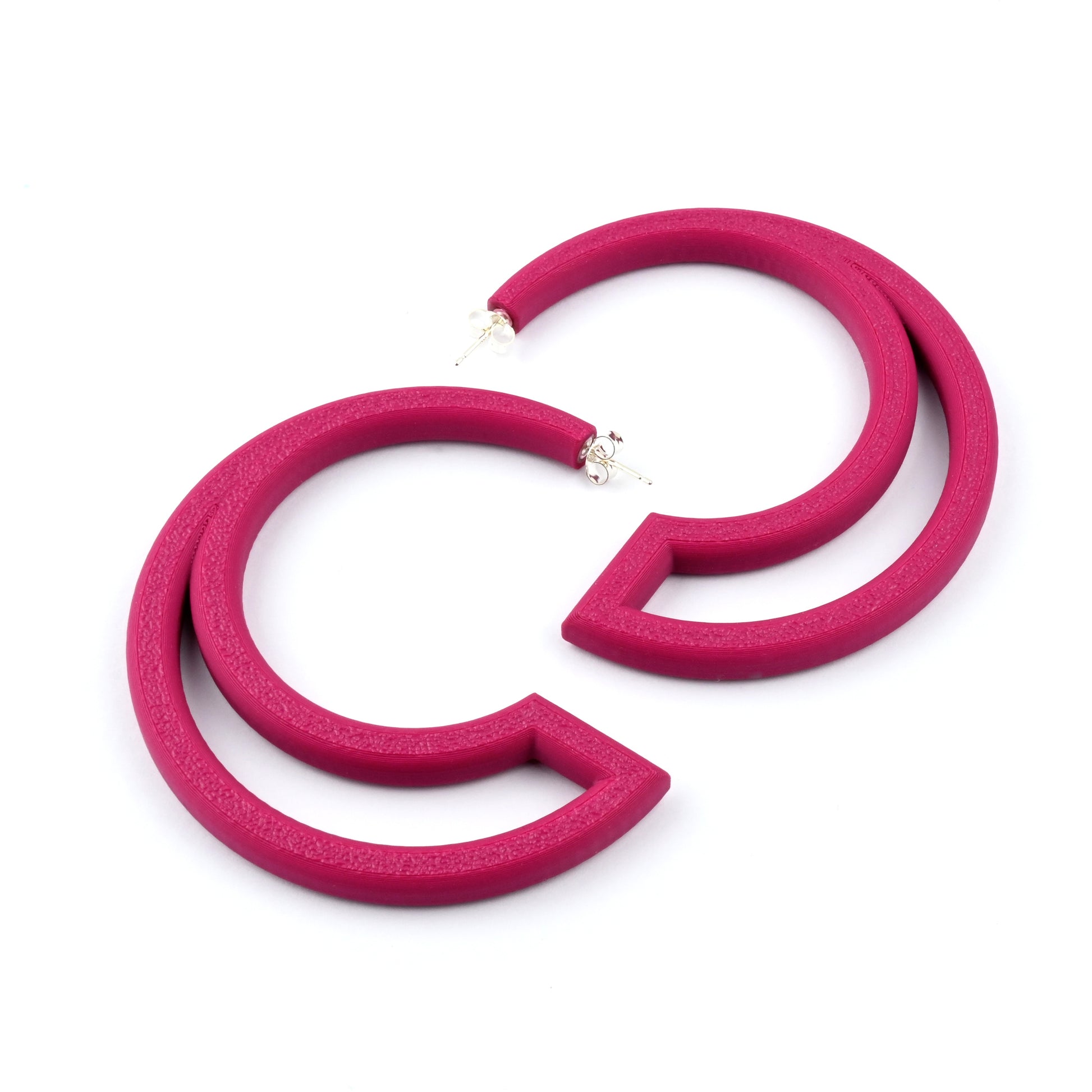 Plum coloured hoop earrings with large cut out section on a white background