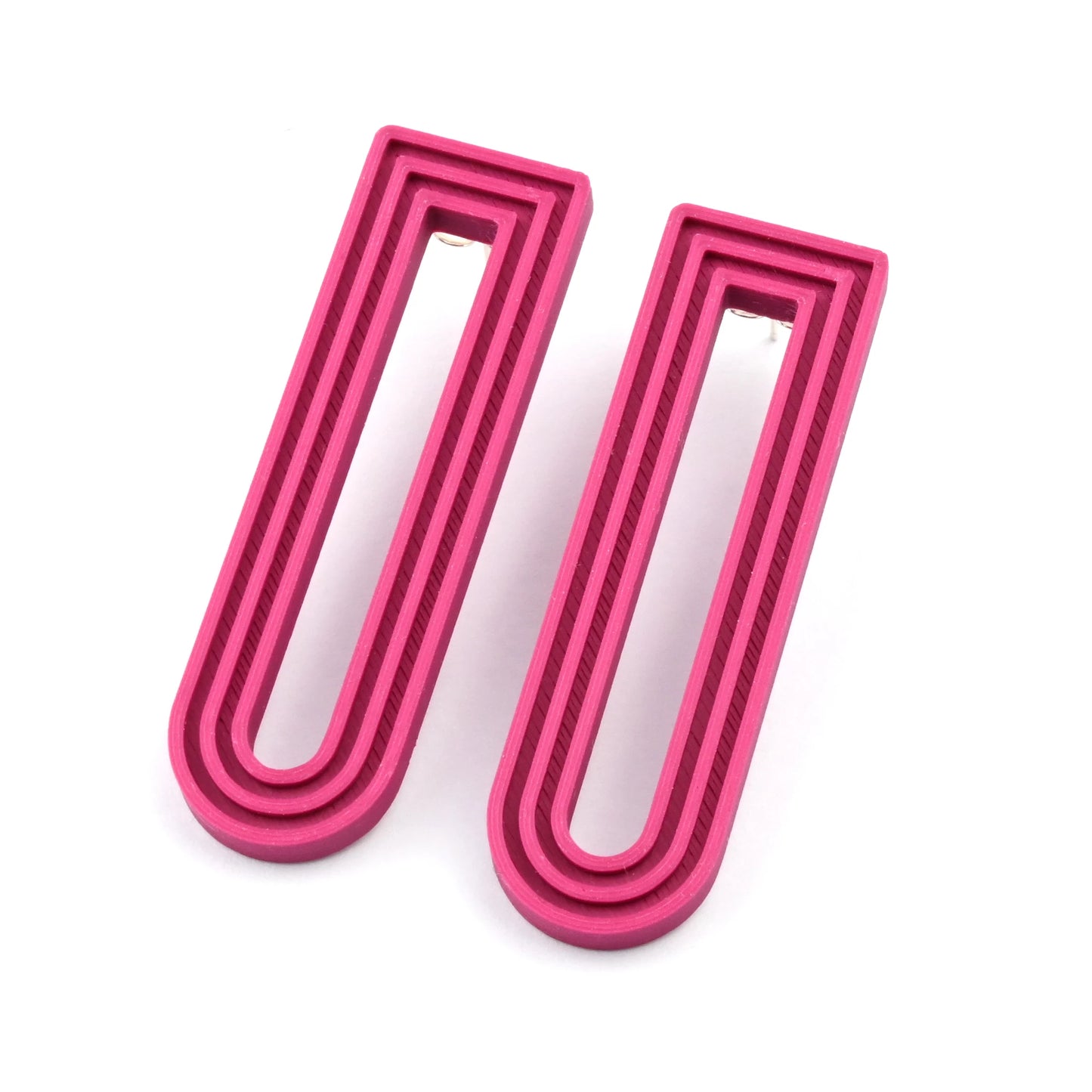 Plum U-shaped drop earrings with raised linear design on a white background