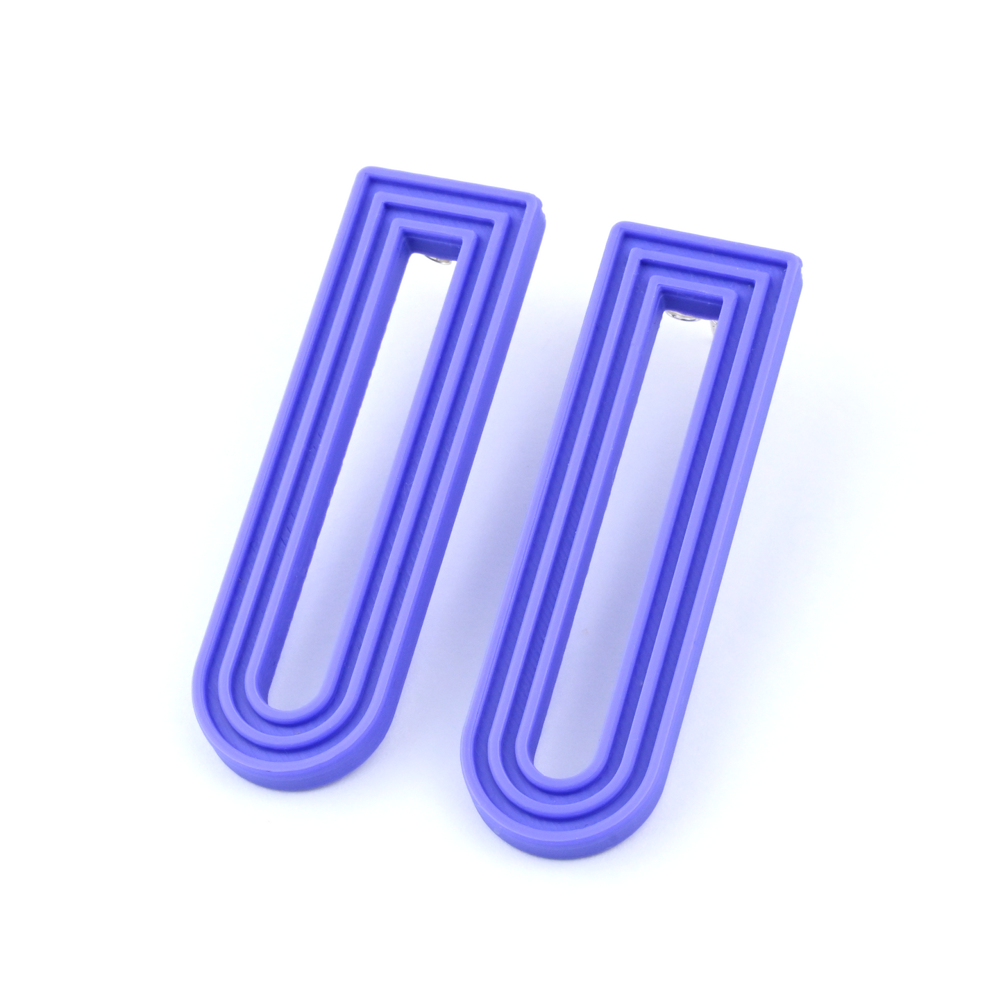 Pair of purple U-shaped drop earrings with raised linear design on a white background