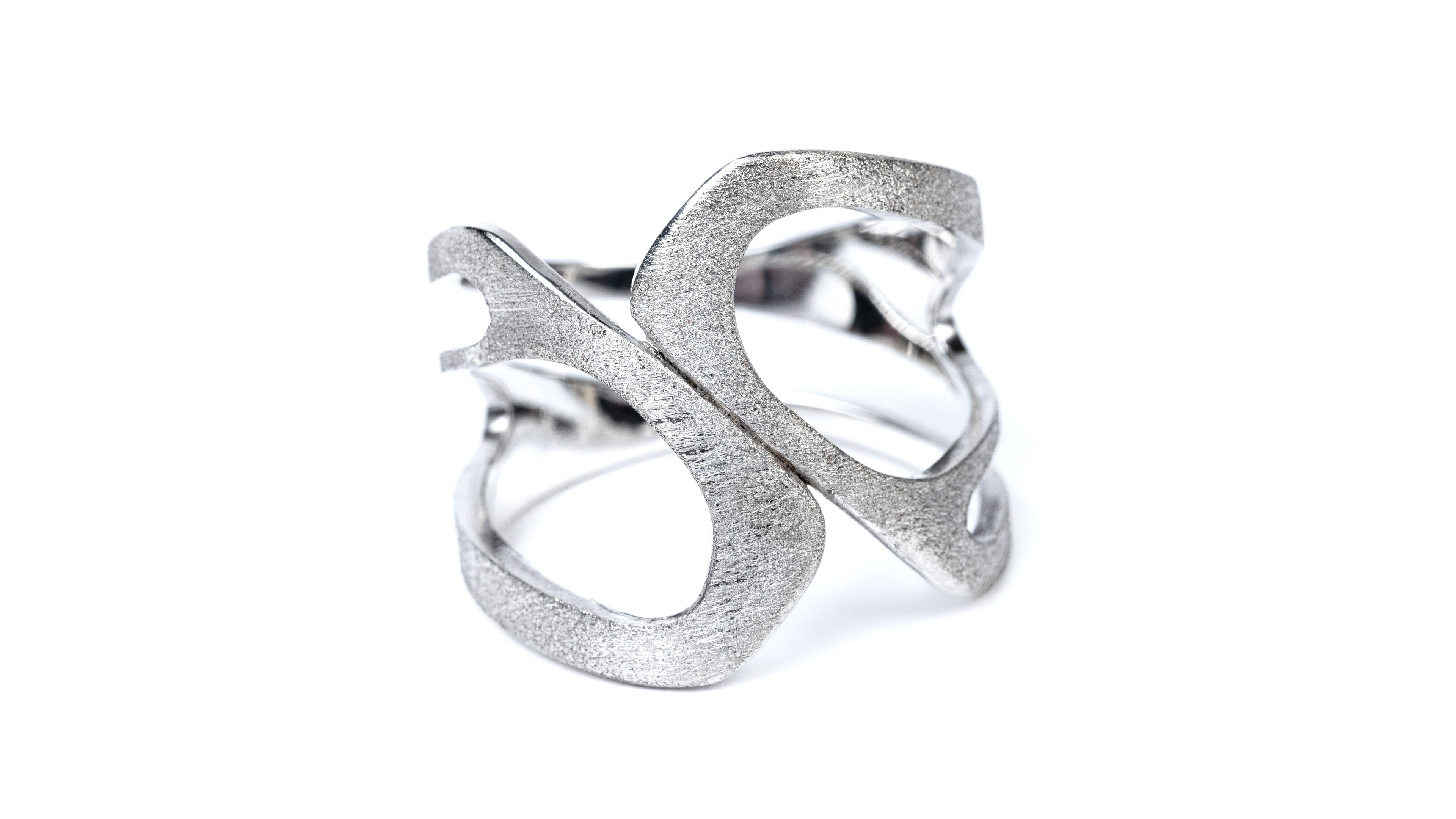 Wide silver ring with a curved profile and curved cut out design.  It has a frosted external finish and shiny inside.
