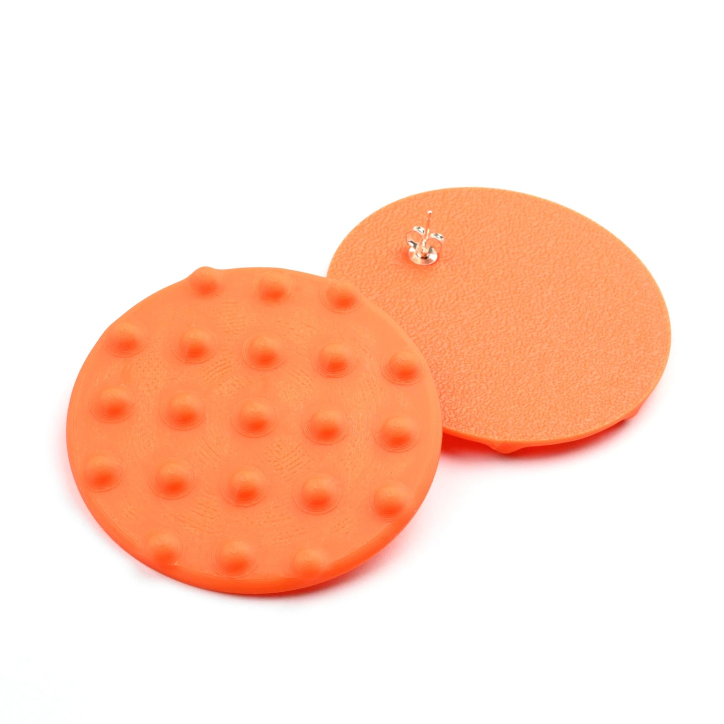 Oversized orange Disk Stud Earrings with Raised Dots on a white background.