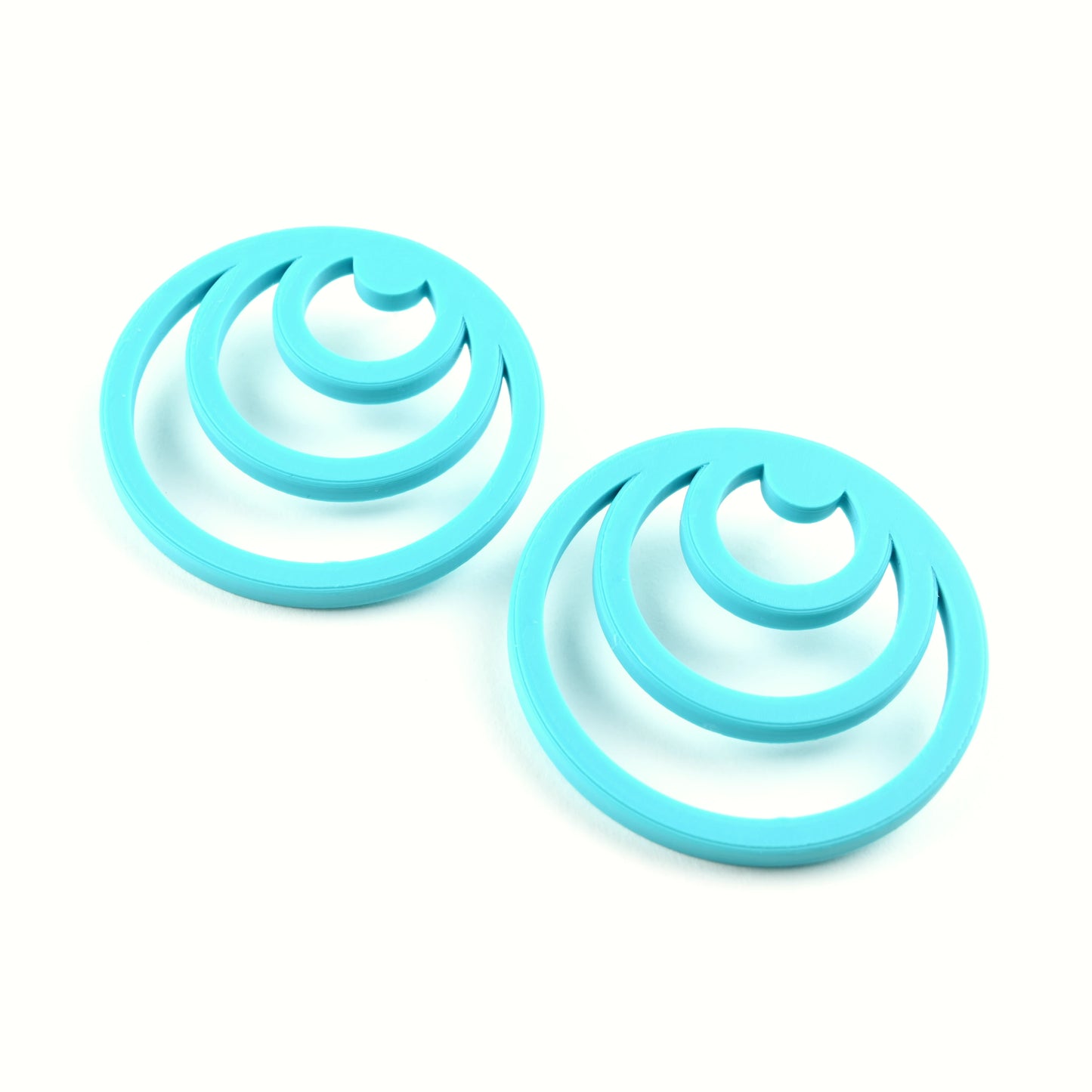 Pair of orange earrings with three orange cirlces inside each other on a white background