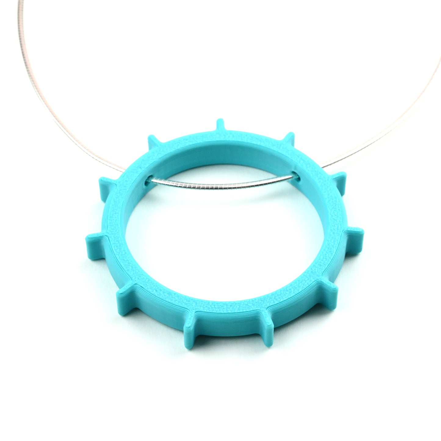 Turquoise necklace with a unique circular design on a silver cable necklet on a white background