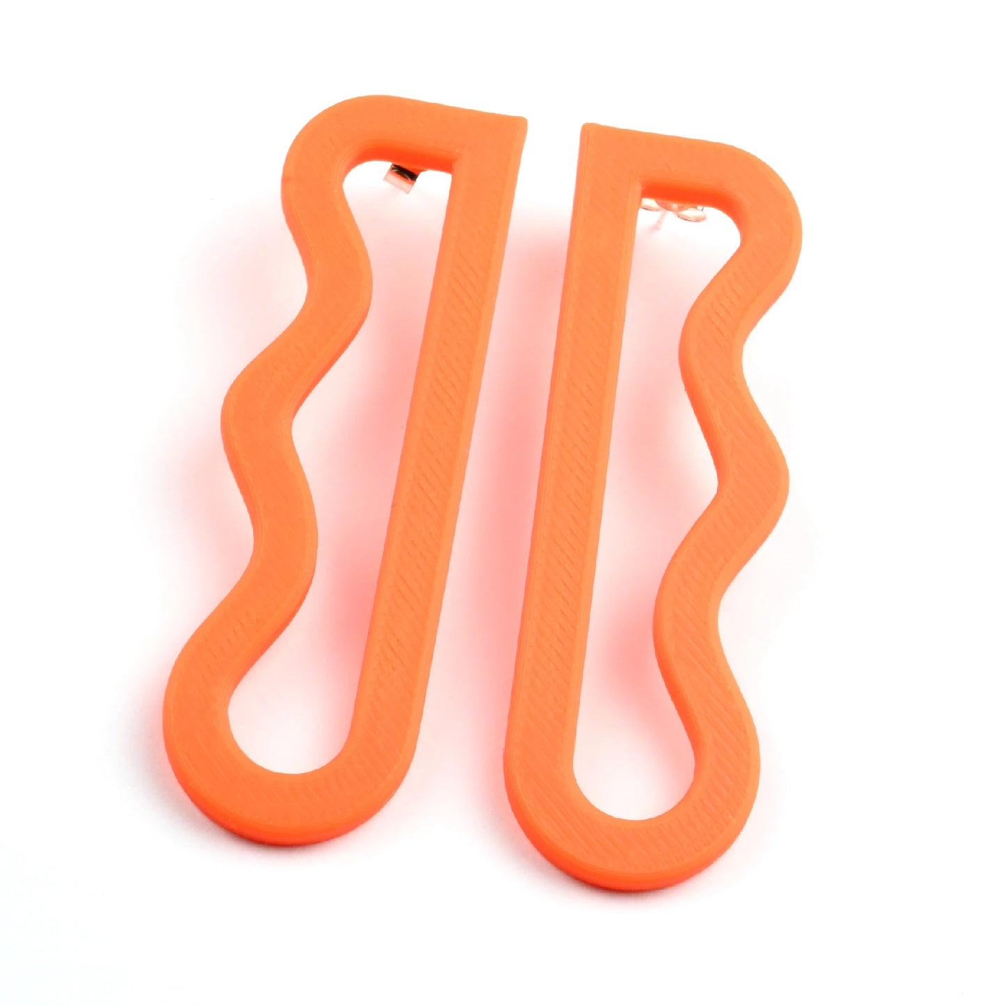 3D printed orange wavy drop earrings by Roxwoods on a white background