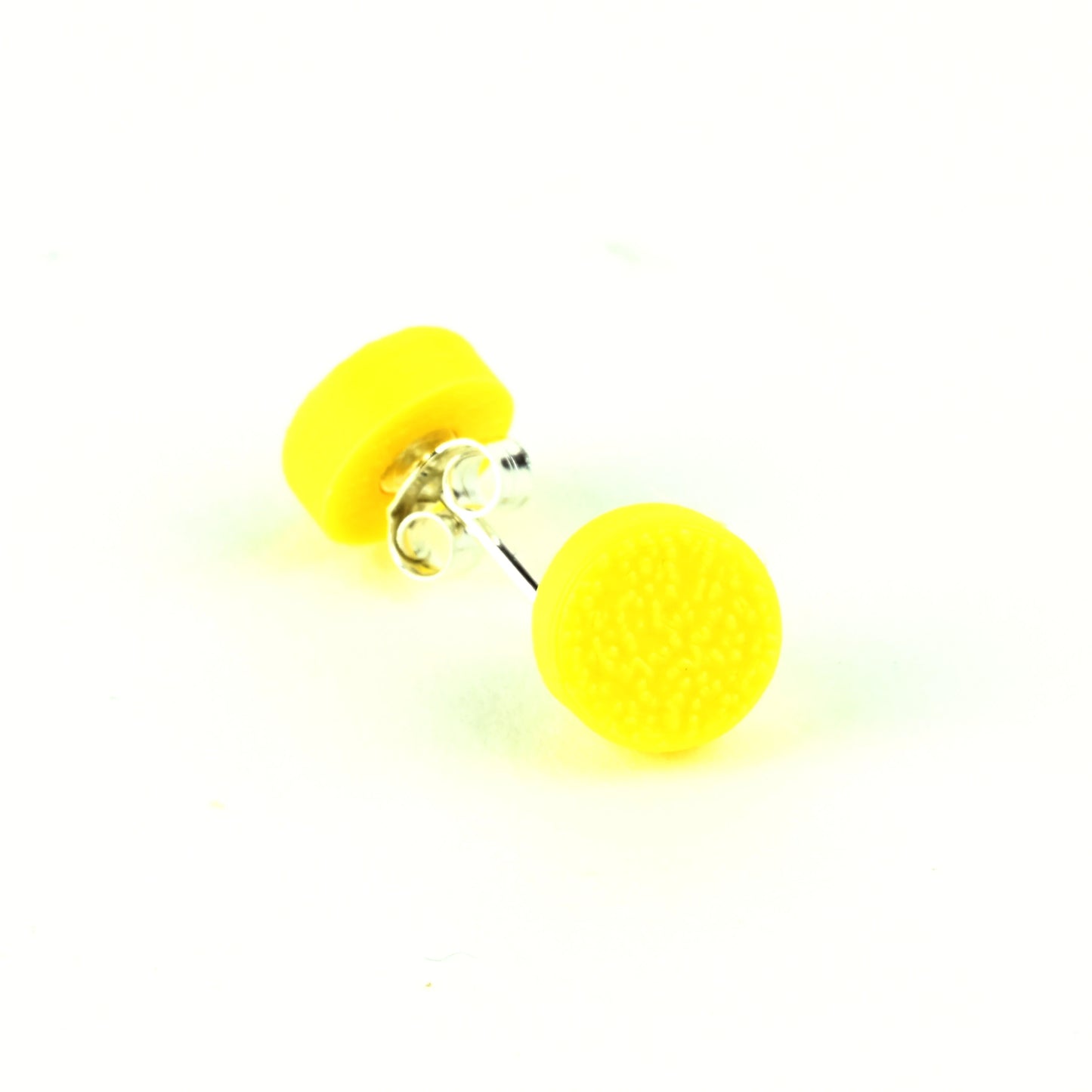 Tiny yellow stud earrings with a textured surface on a white background