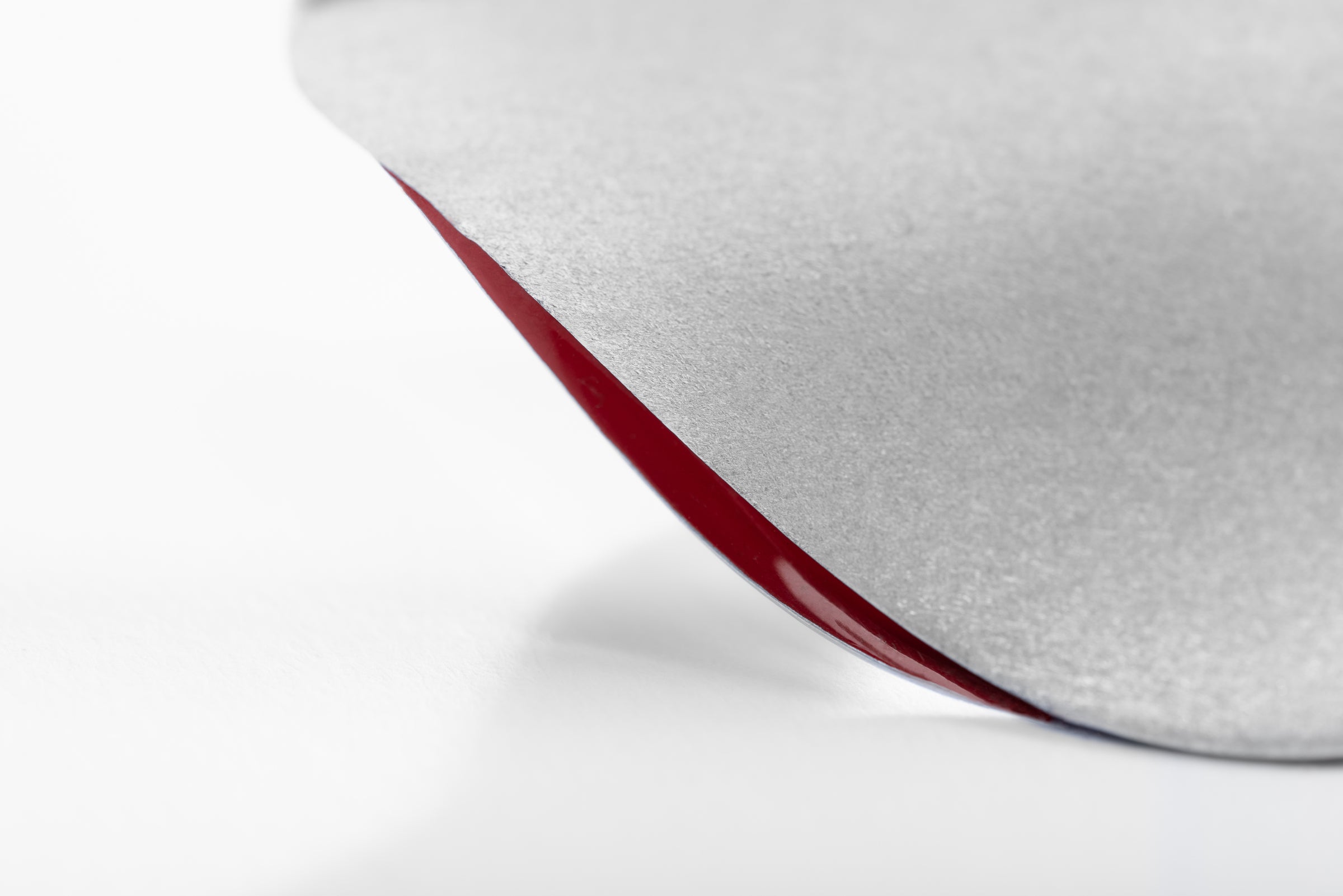 Close up of statement silver ring with sliver of red enamel visible between the layers of silver.