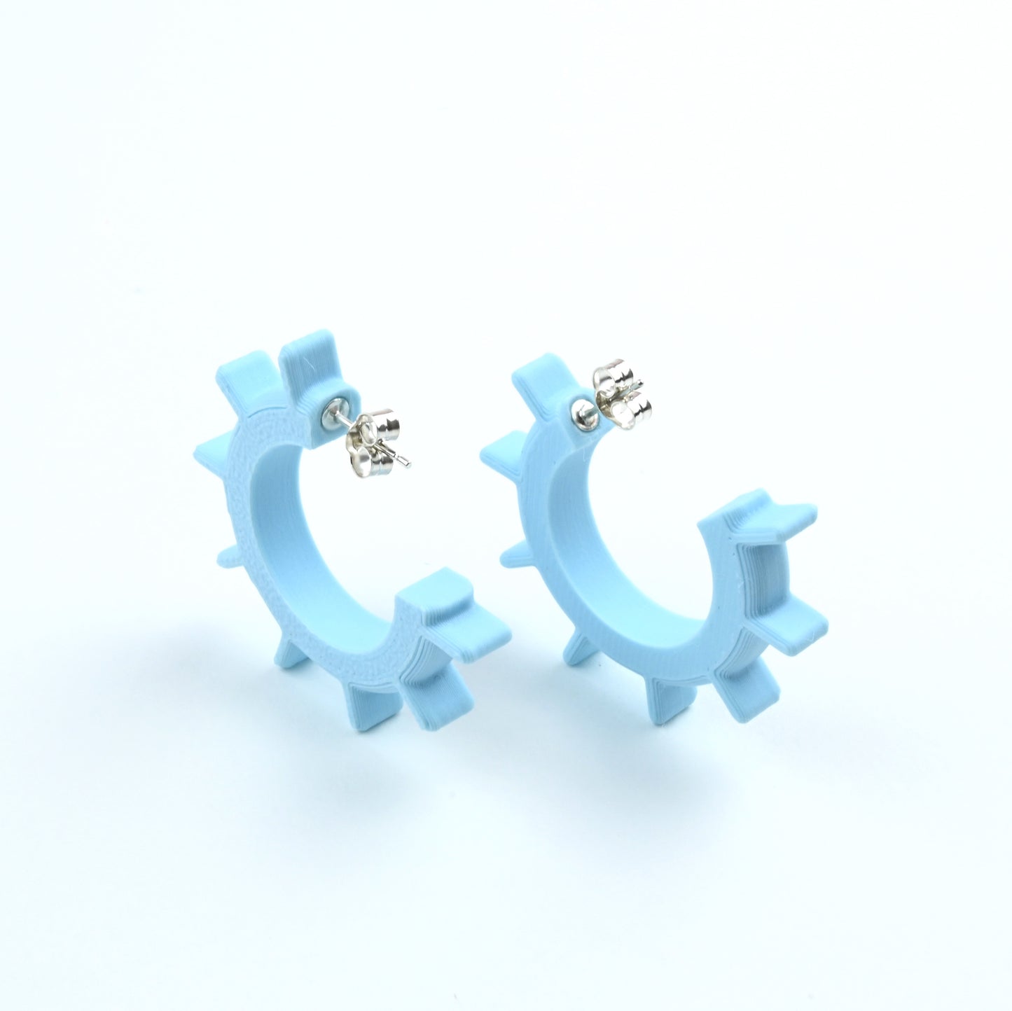 Light blue hoop earrings on a white background with silver ear posts.
