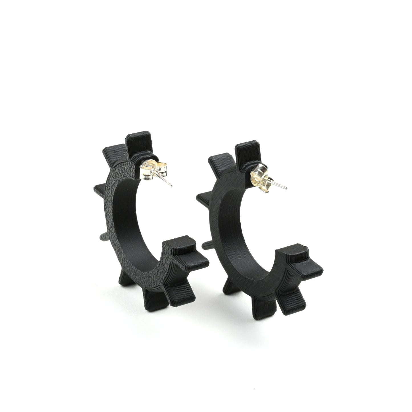 Small black hoop earrings on a white background with silver ear posts and earring backs.  The hoops have spikes along the front edge.