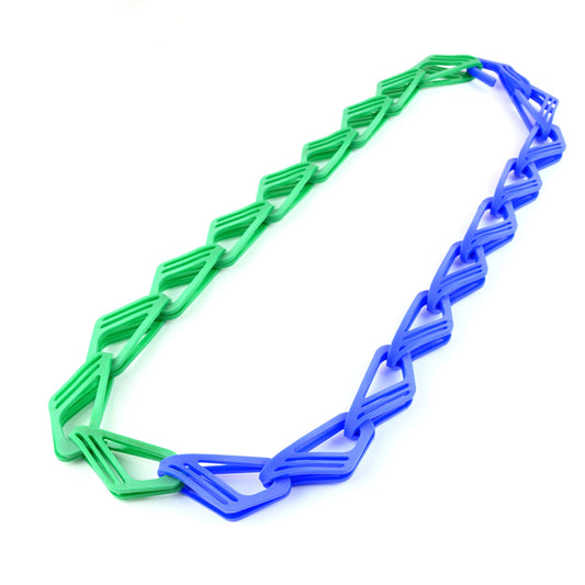 A necklace with interlocking geometric links in green and blue, displayed on a white background.