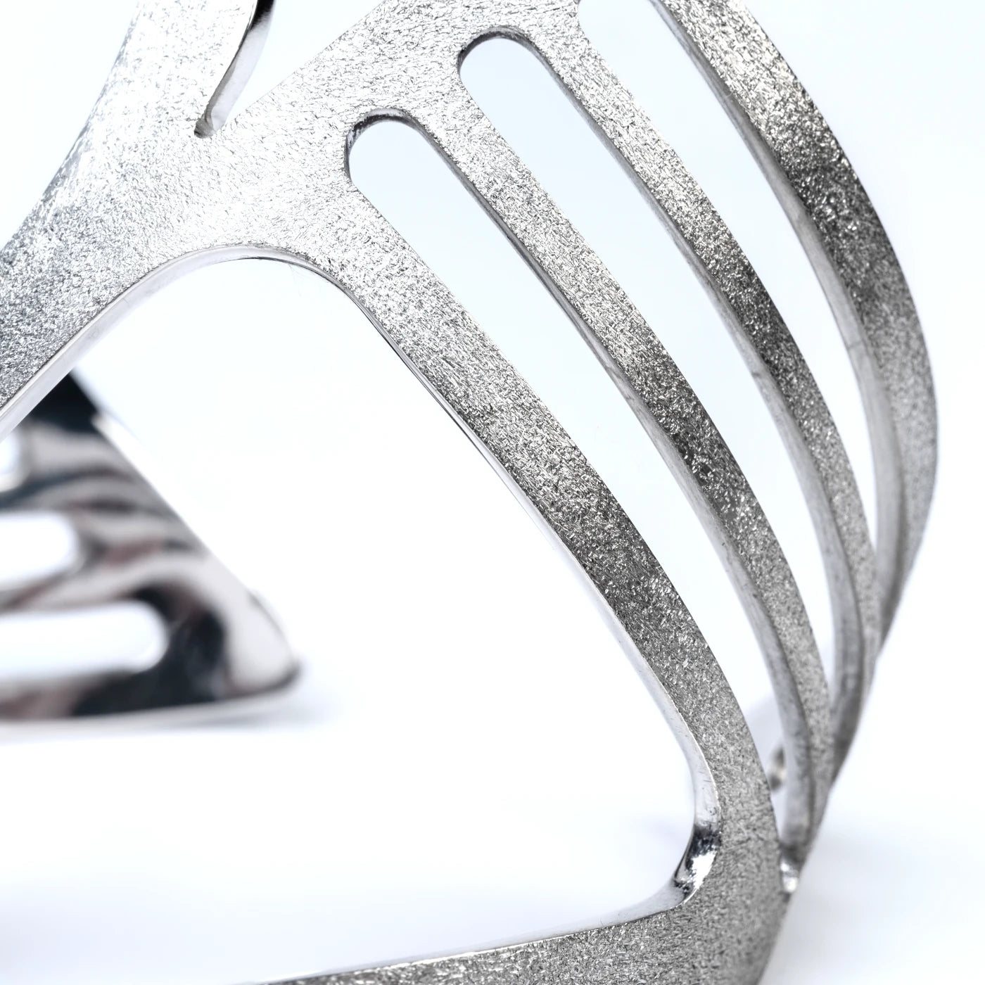 Close-up of a silver cuff with a sparkly textured surface on a white background