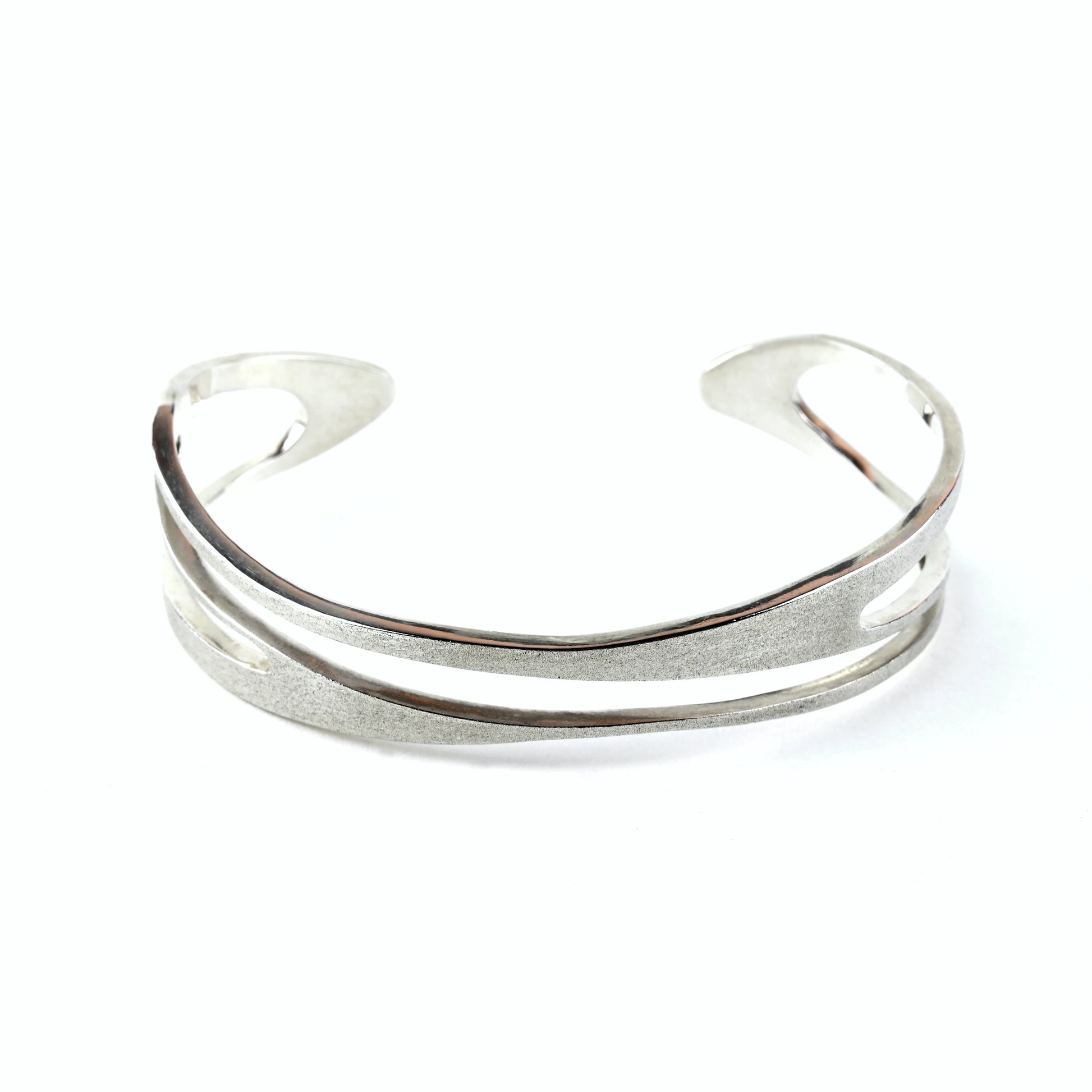 Mens silver cuff bracelet with curved shape and curved cut out areas on a white background