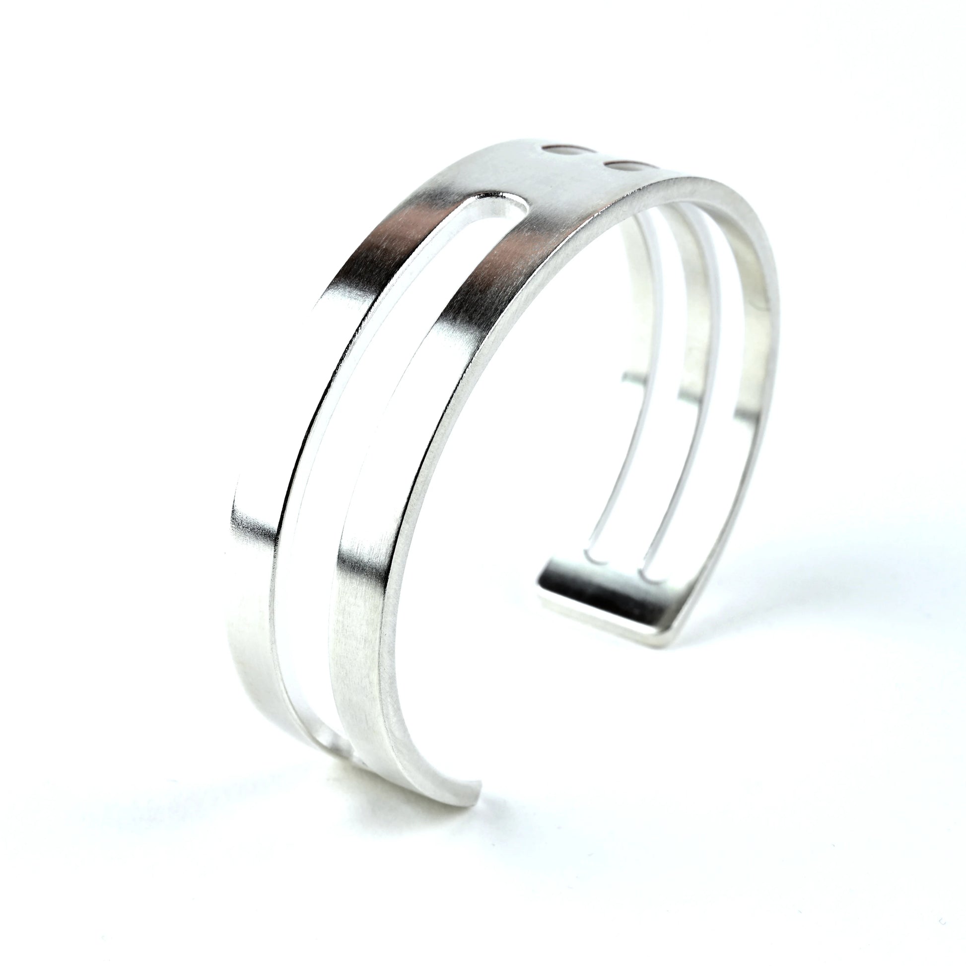 Mens sterling silver cuff bracelet with geometric linear design on a white background
