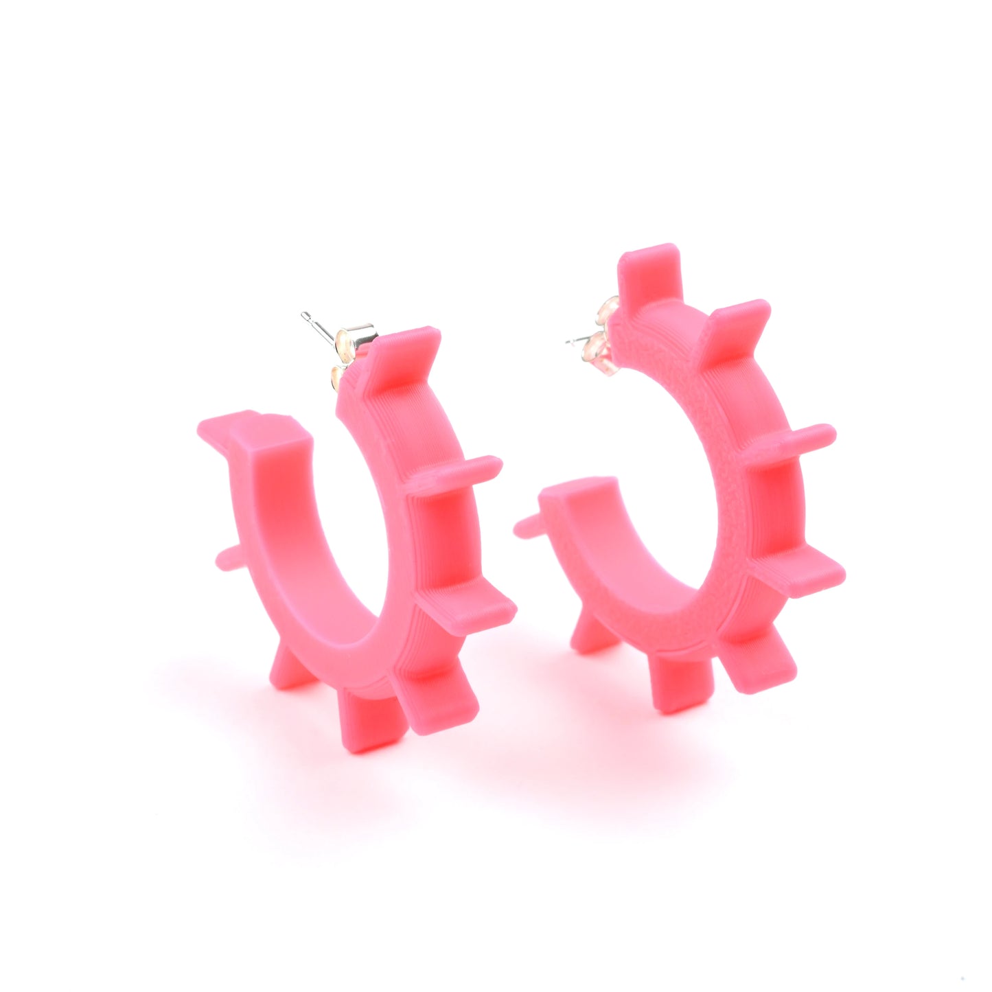 Small pink hoop earrings with spikes on a white background