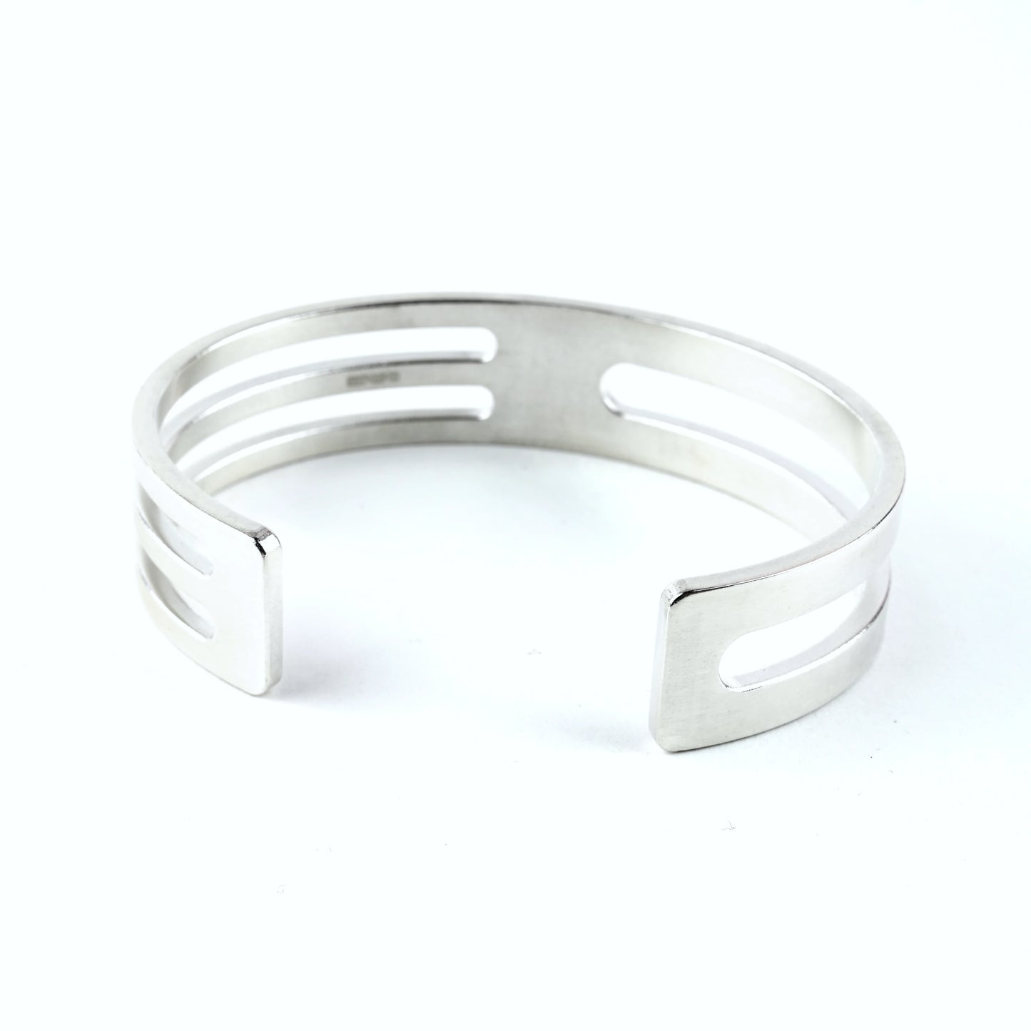 Mens sterling silver cuff bracelet with geometric cut outs on a white background