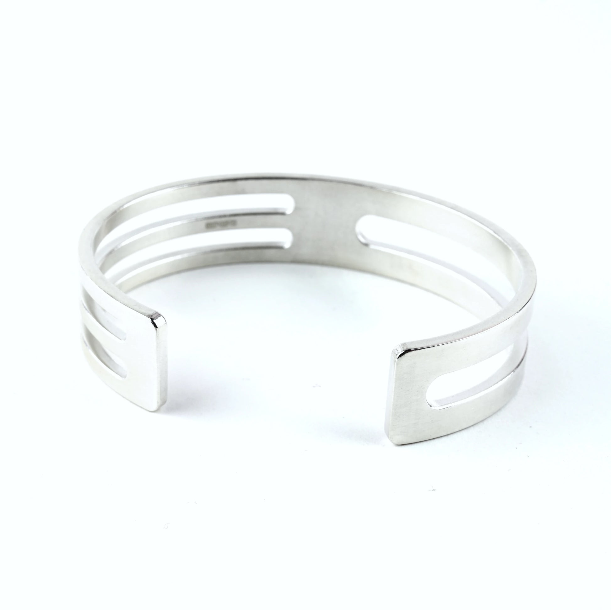 Mens sterling silver cuff bracelet with geometric cut outs on a white background