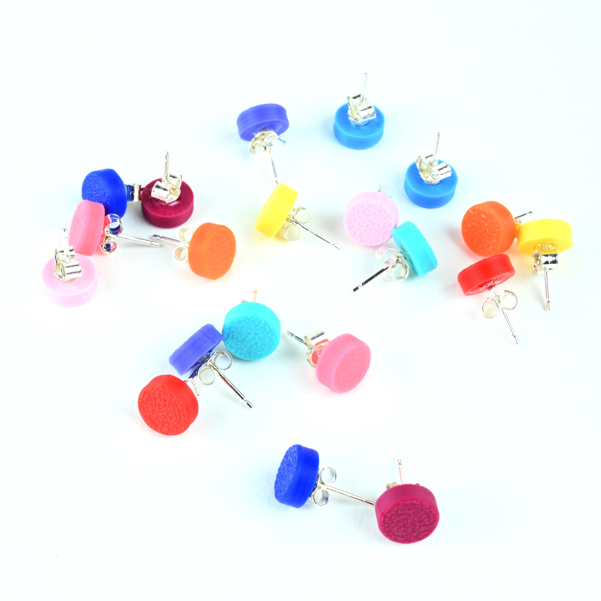 Lots of colorful stud earrings on a white background