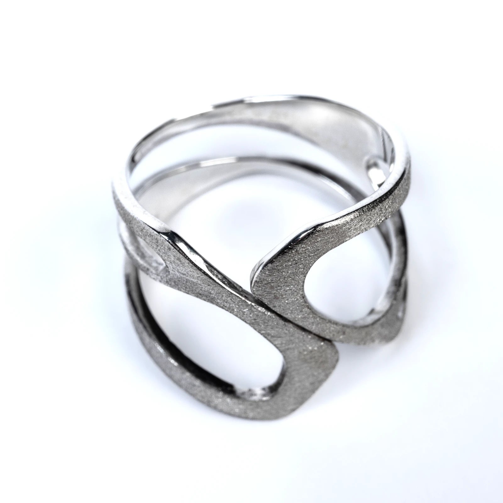 Silver ring with a frosted textured design on a white background