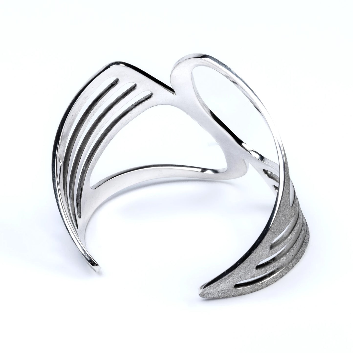 Silver cuff with geometric design and polished interior on a white background