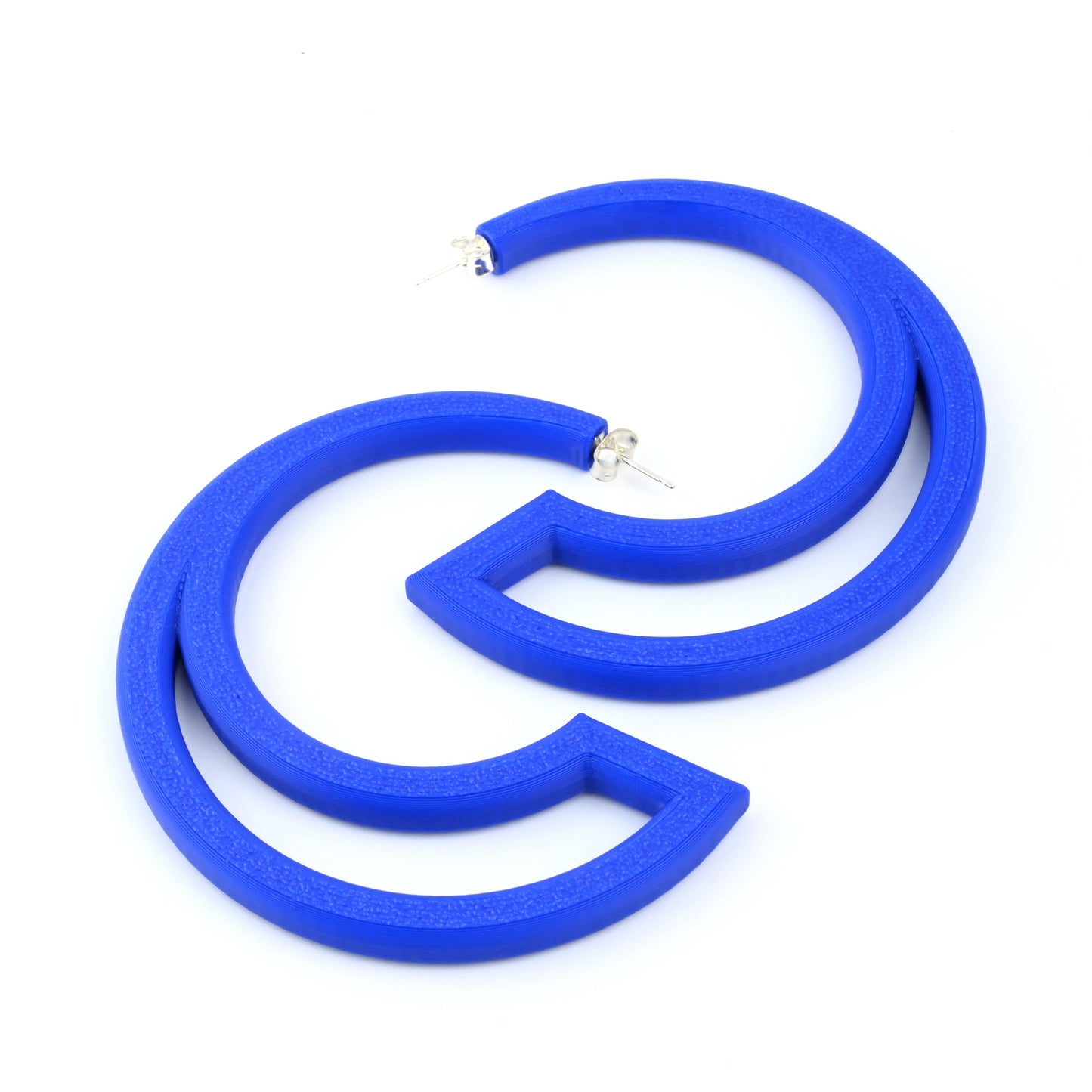 Blue hoop earrings with large cut out section on a white background