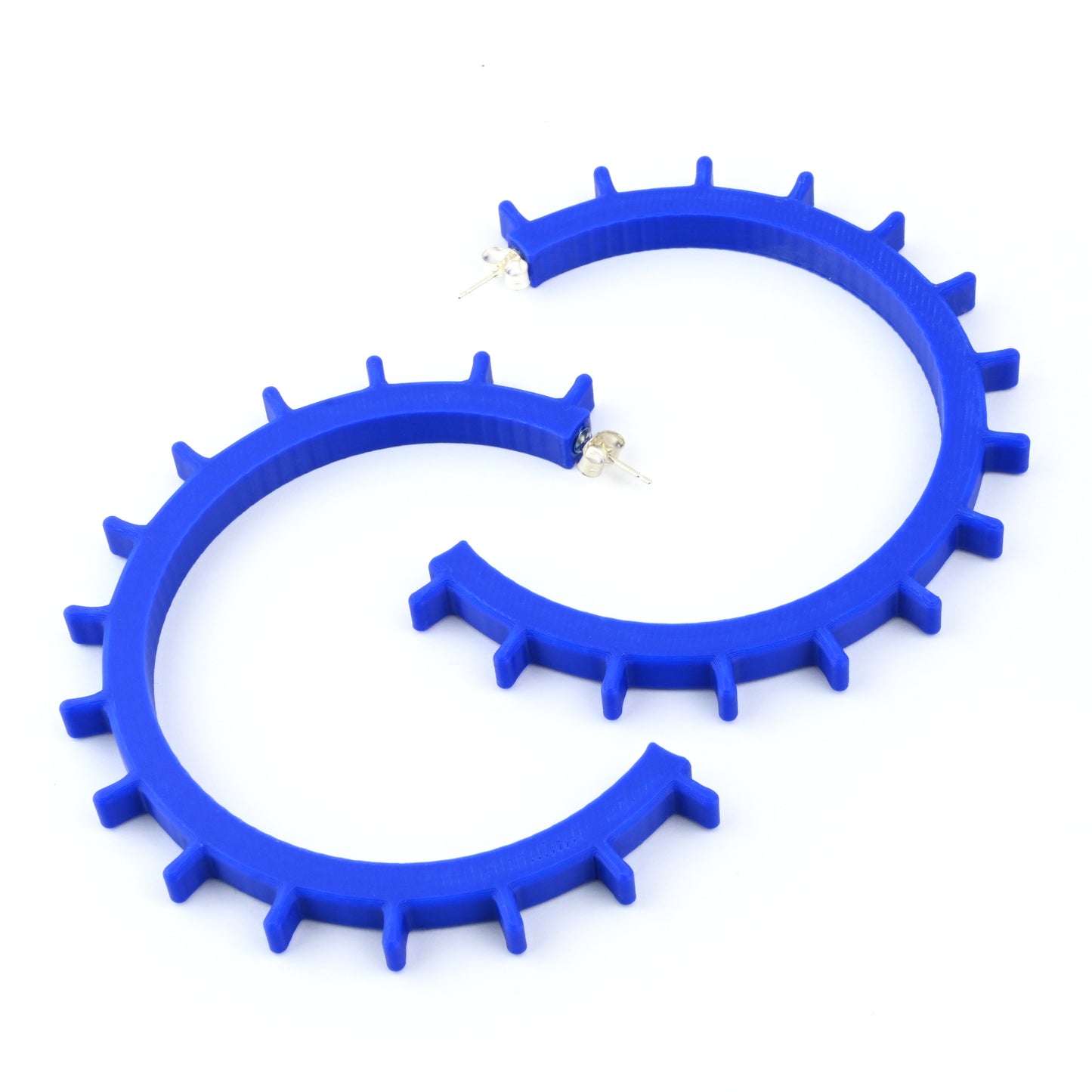 Pair of big blue cog shaped hoop earrings with silver ear posts on a white background