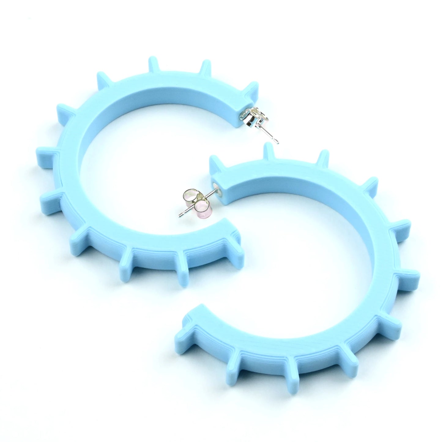 Medium sized pale blue hoop earrings with silver ear posts with ridge design on a white background.