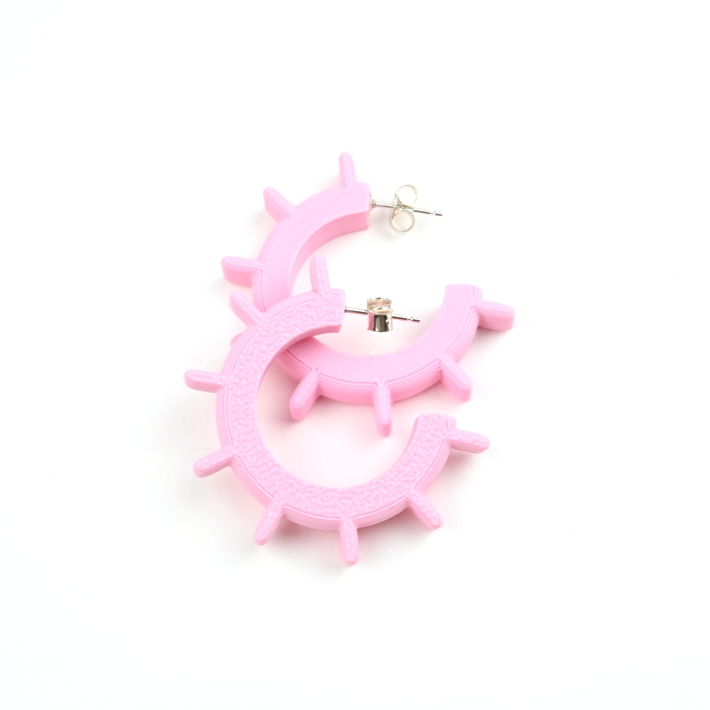 Pale pink hoop earrings on a white background with silver ear posts.
