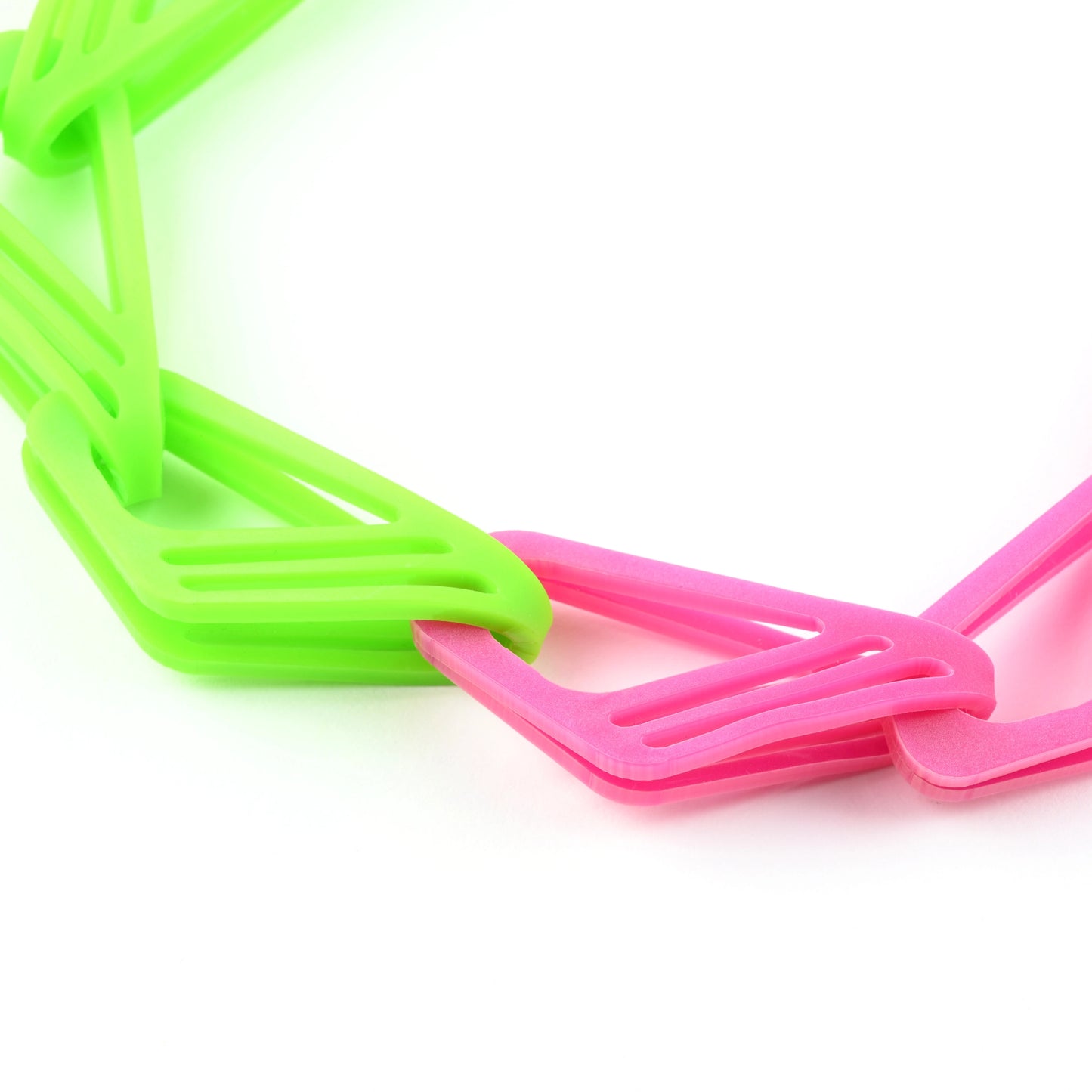 Close up of statement lime green and pink chain necklace on a white background