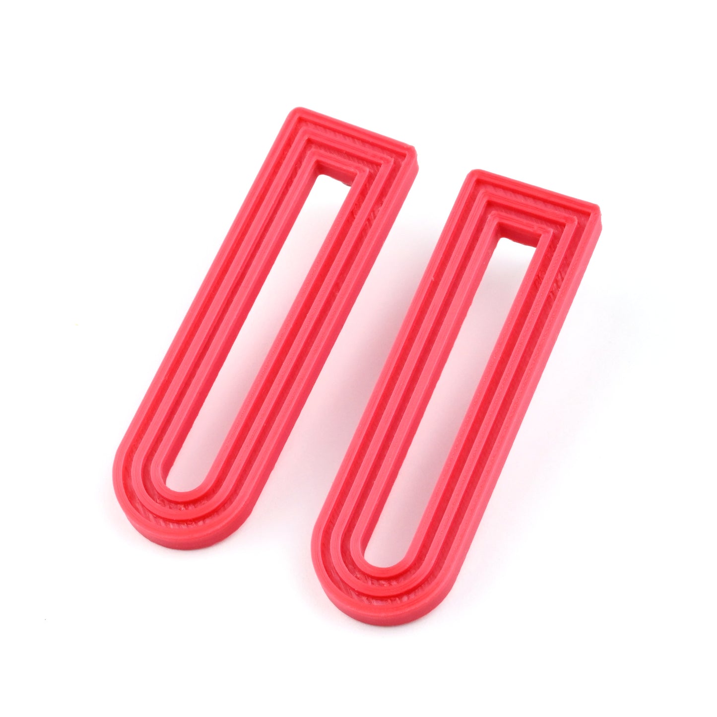 Red U-shaped drop earrings with raised linear design on a white background
