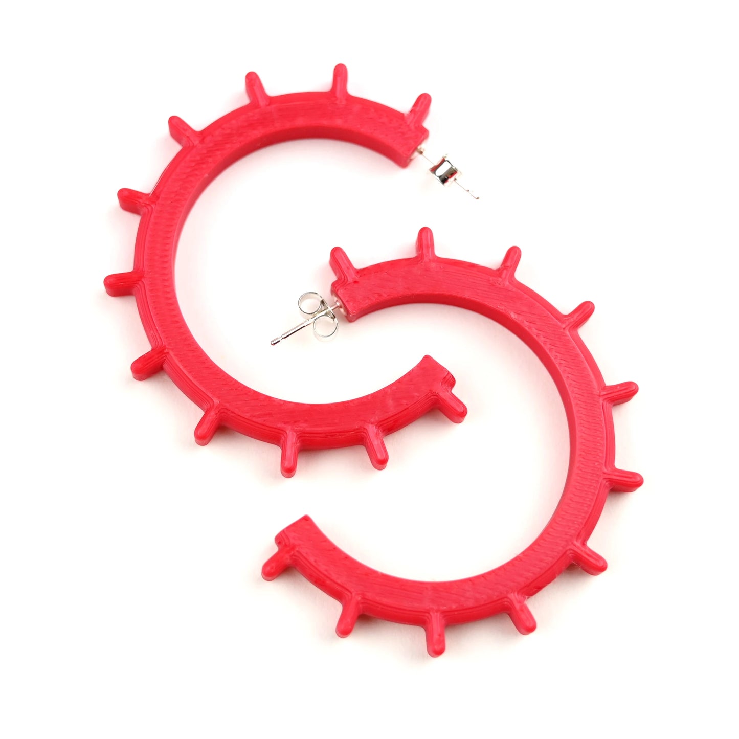 Red cog shaped hoop earrings on a white background