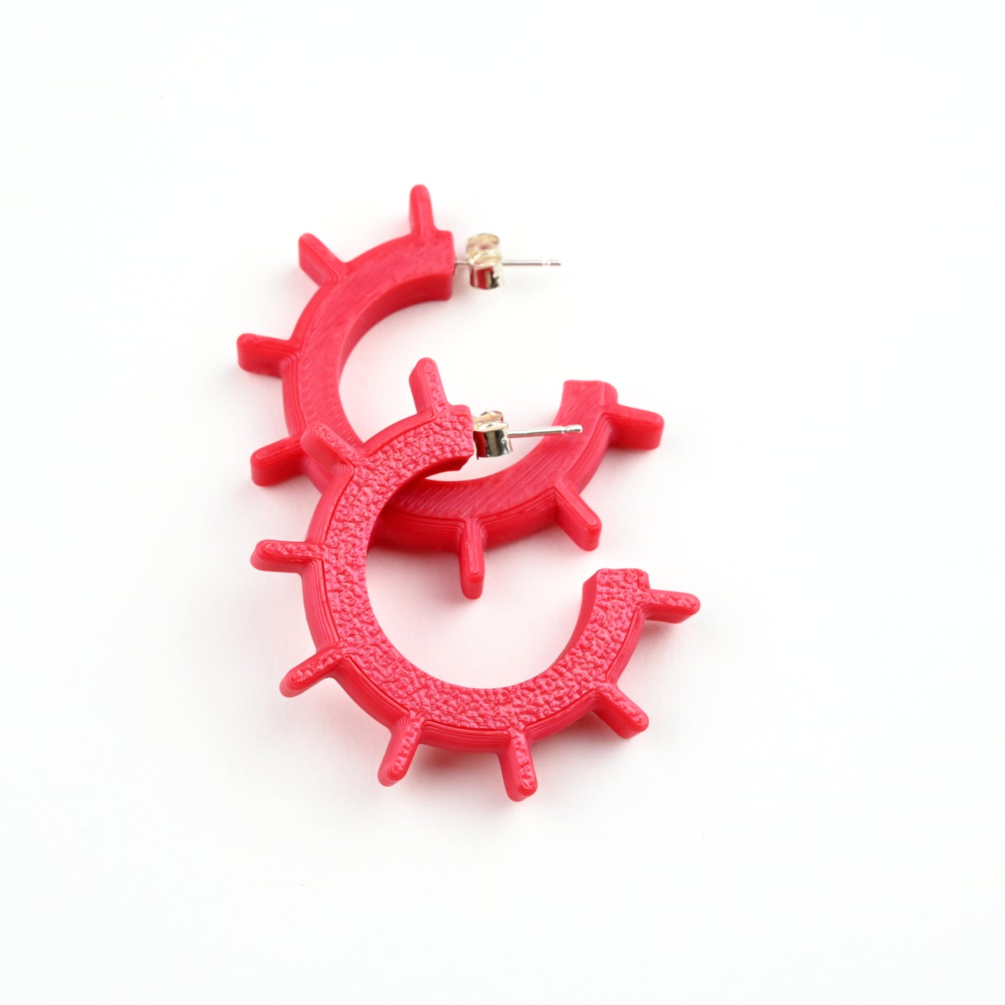 Pair of red hoop earrings on a white background
