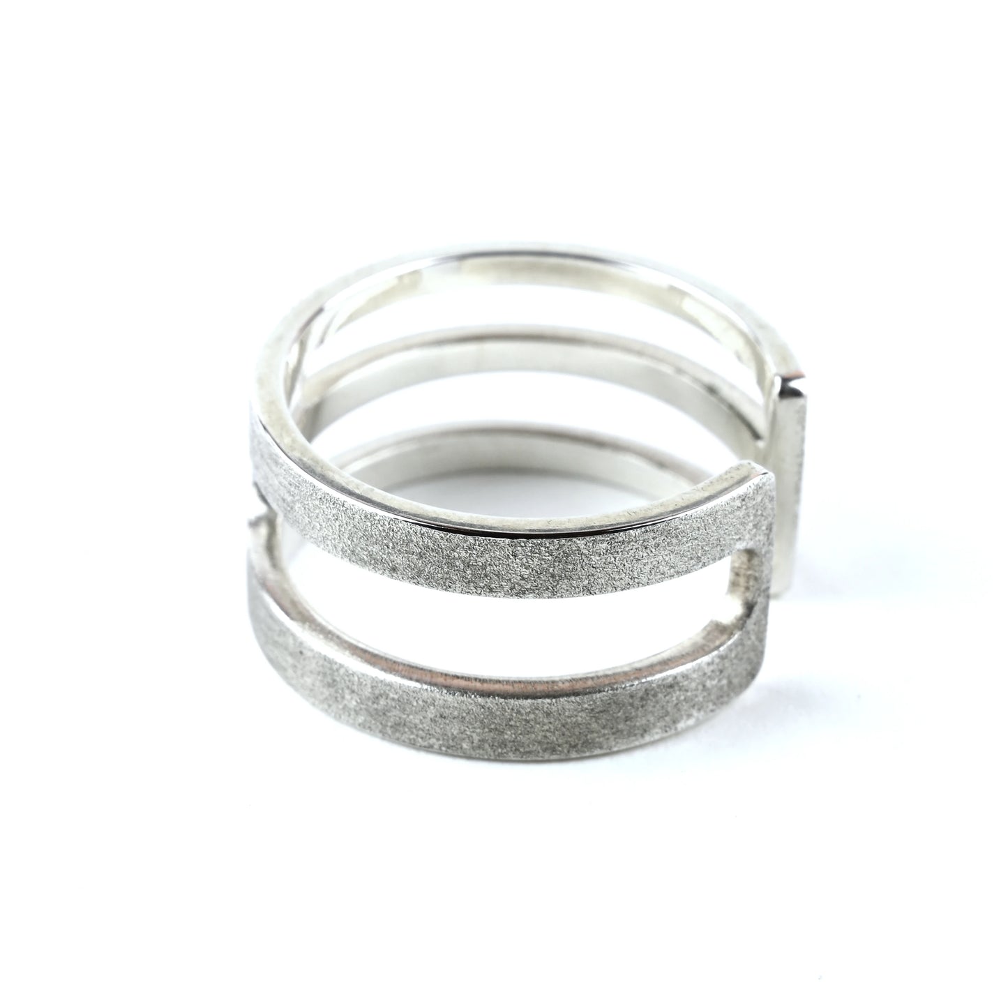 Silver ring with textured design on a white background